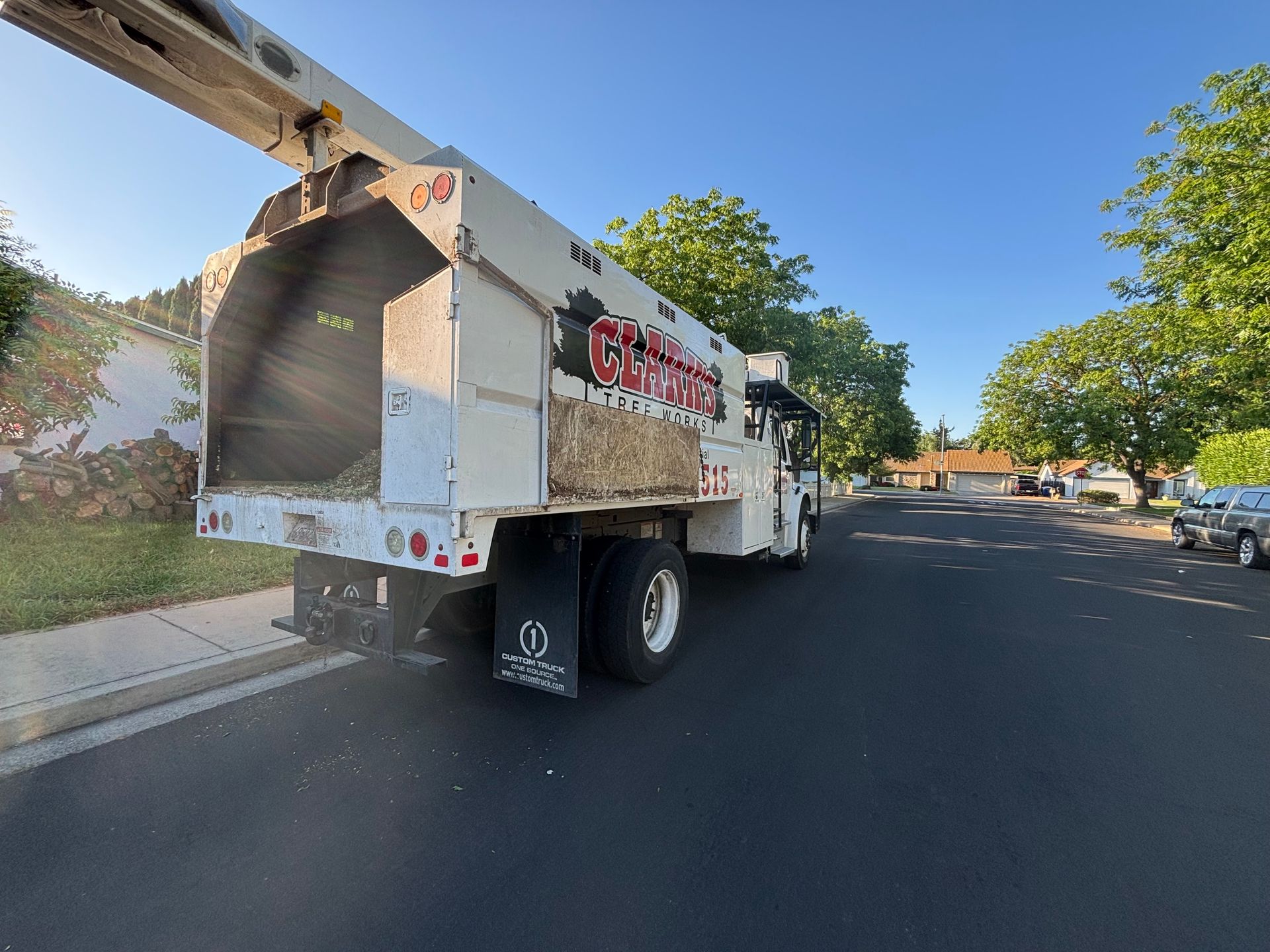 A white utility truck is parked on the side of the road.