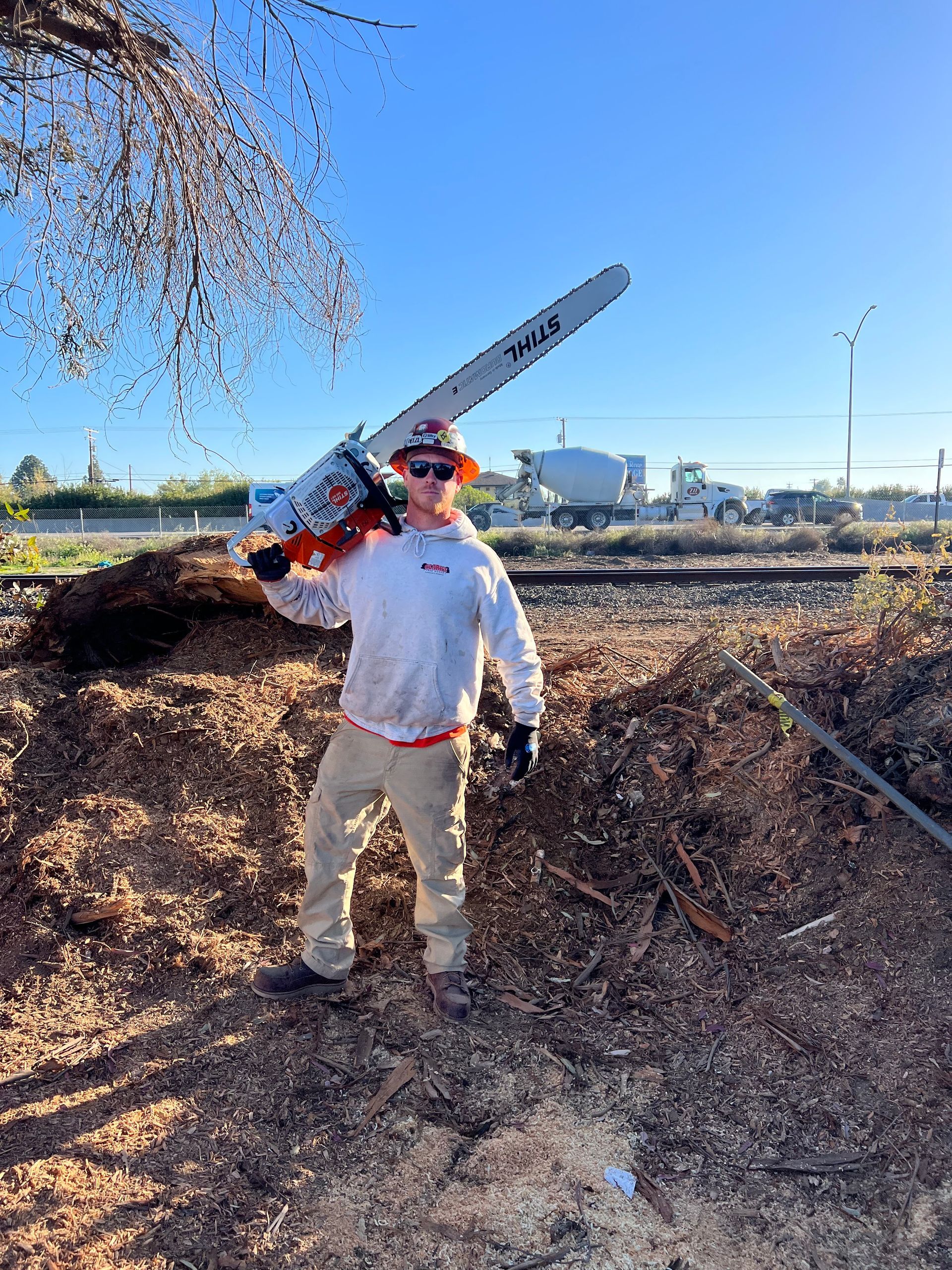 A man is holding a chainsaw over his shoulder.