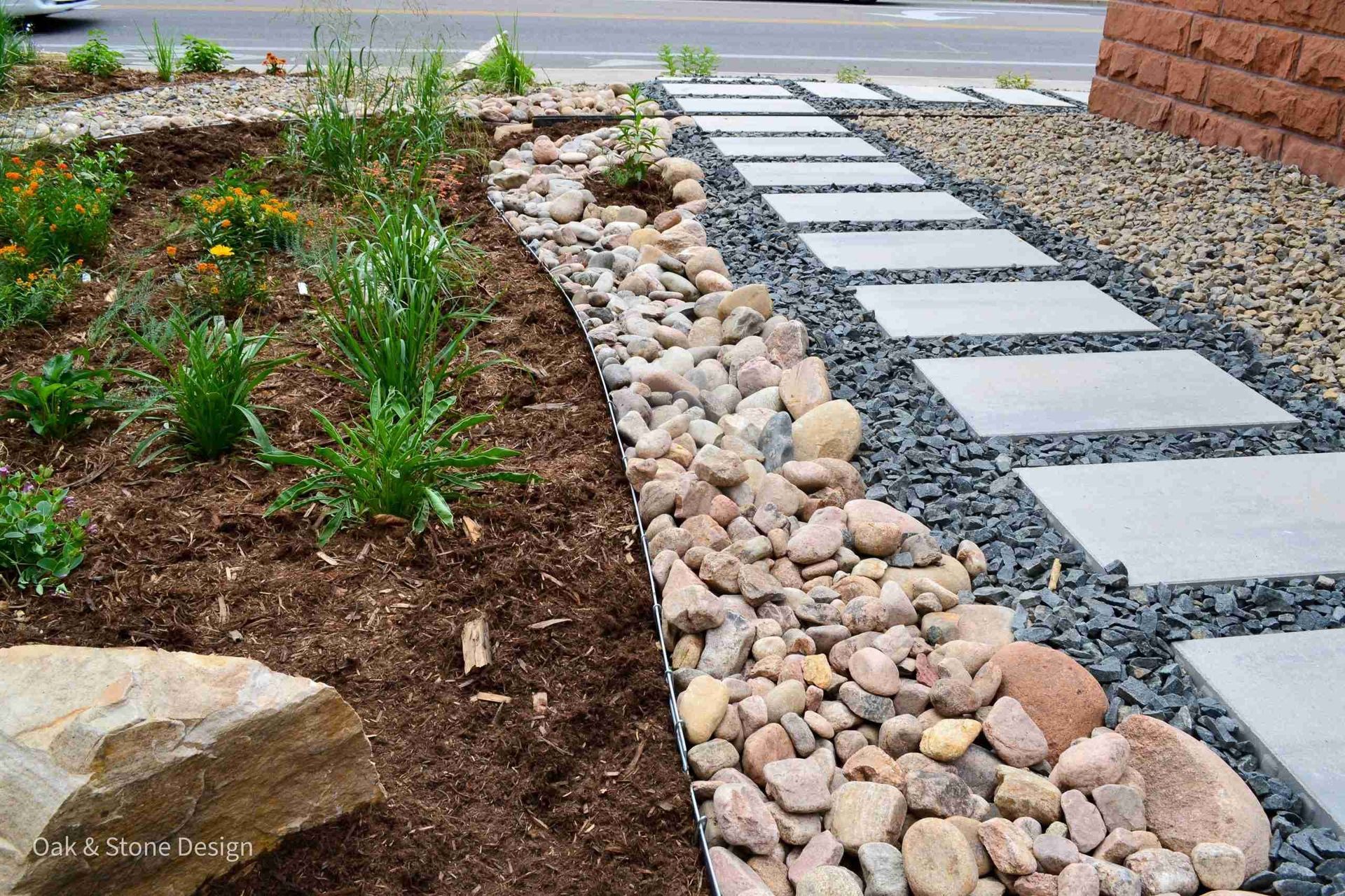 Landscaped garden bed with stepping stones and rock border.