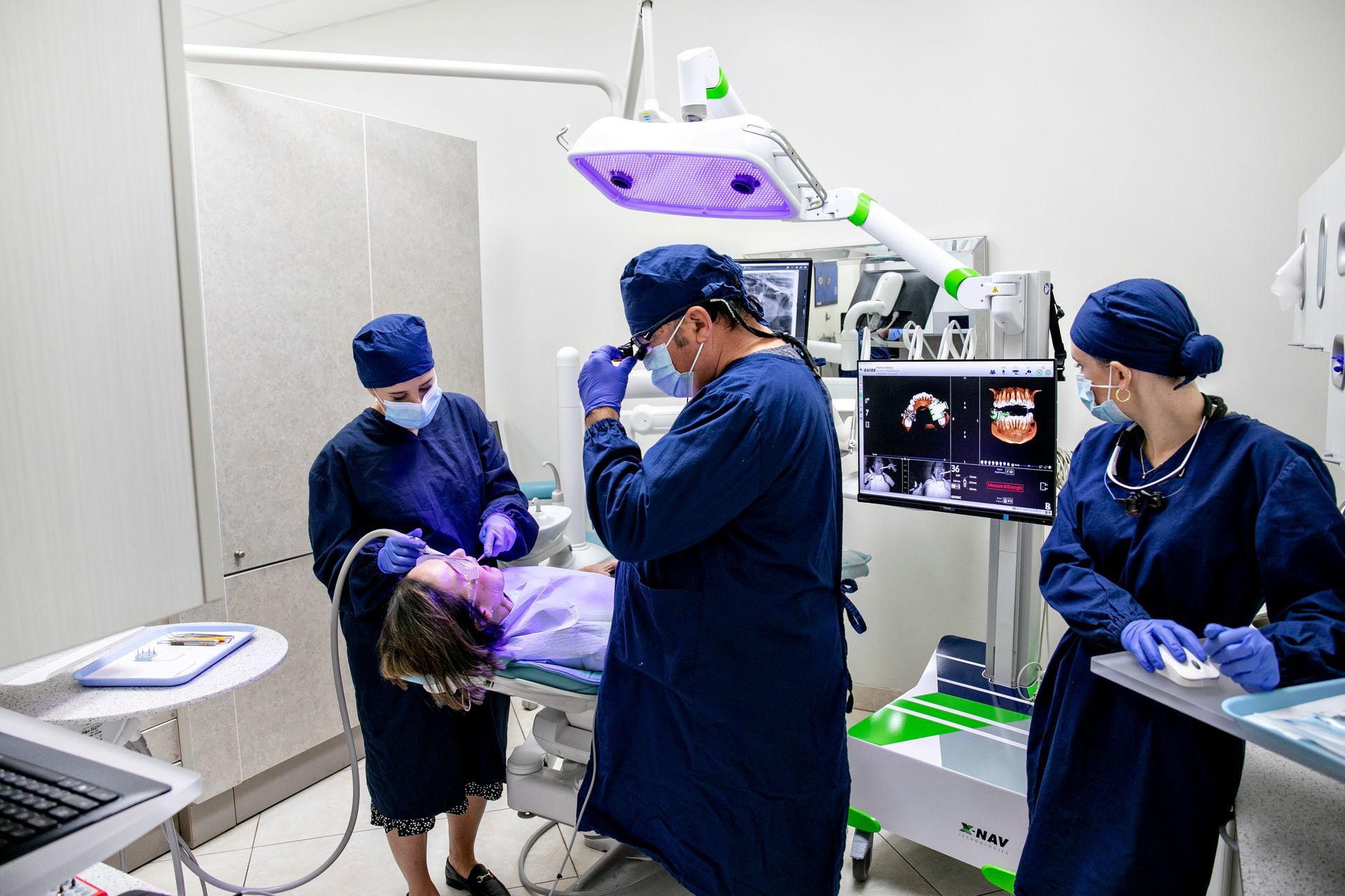 A group of dentists are working on a patient in an operating room.