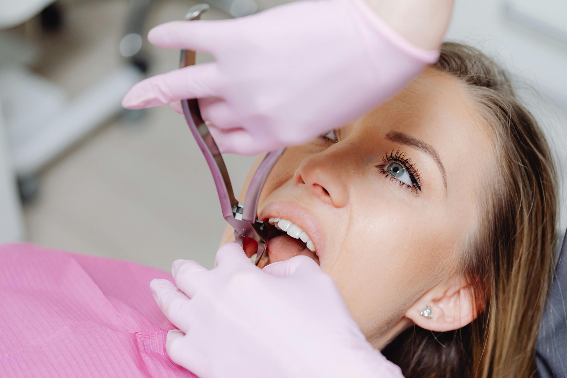 A woman is getting a laser treatment on her face in a dental office.