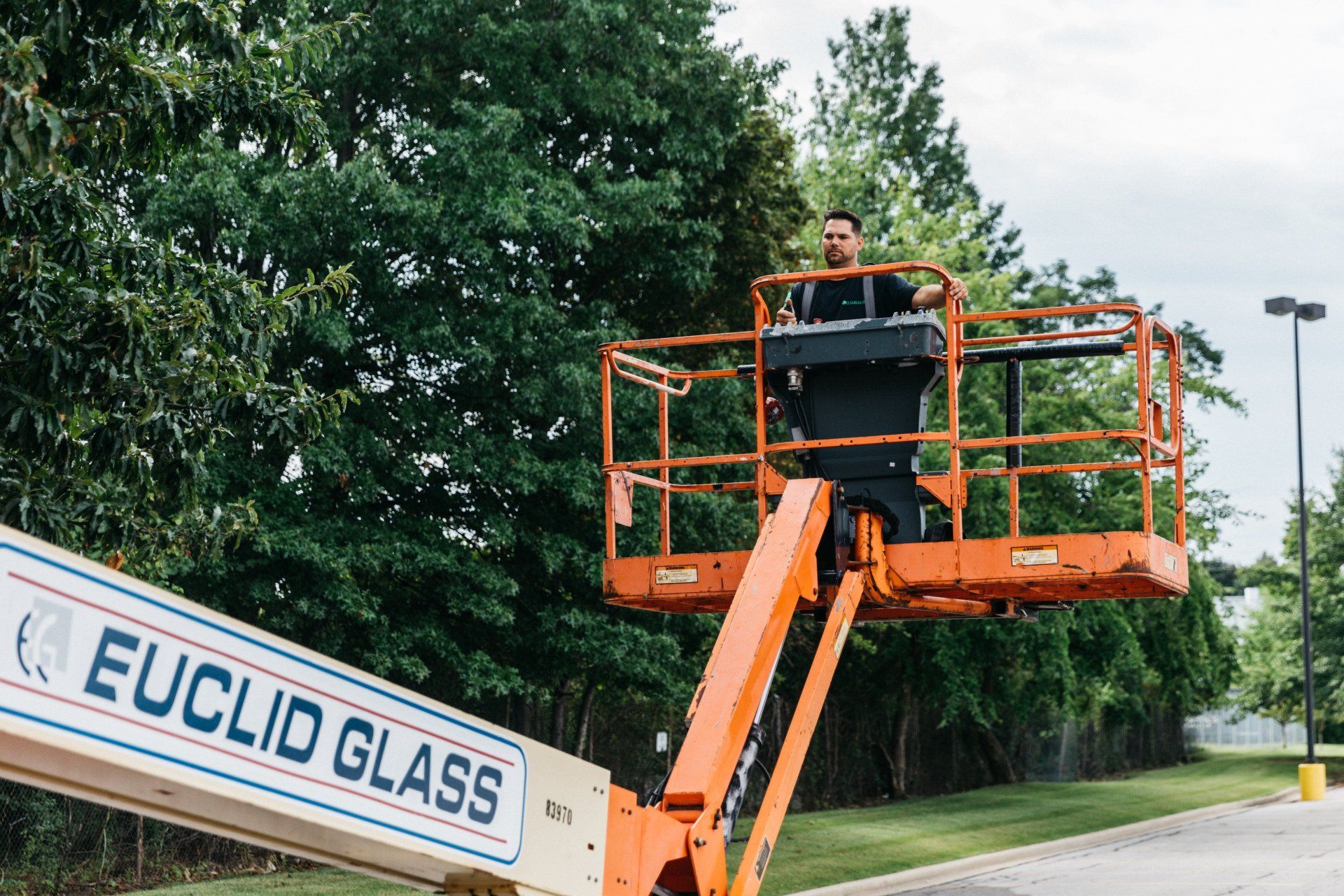 Ryan Harris Riding a Crane — Willoughby, OH — Euclid Glass & Door