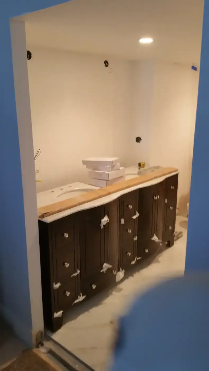 A bathroom with wooden cabinets and a blue wall