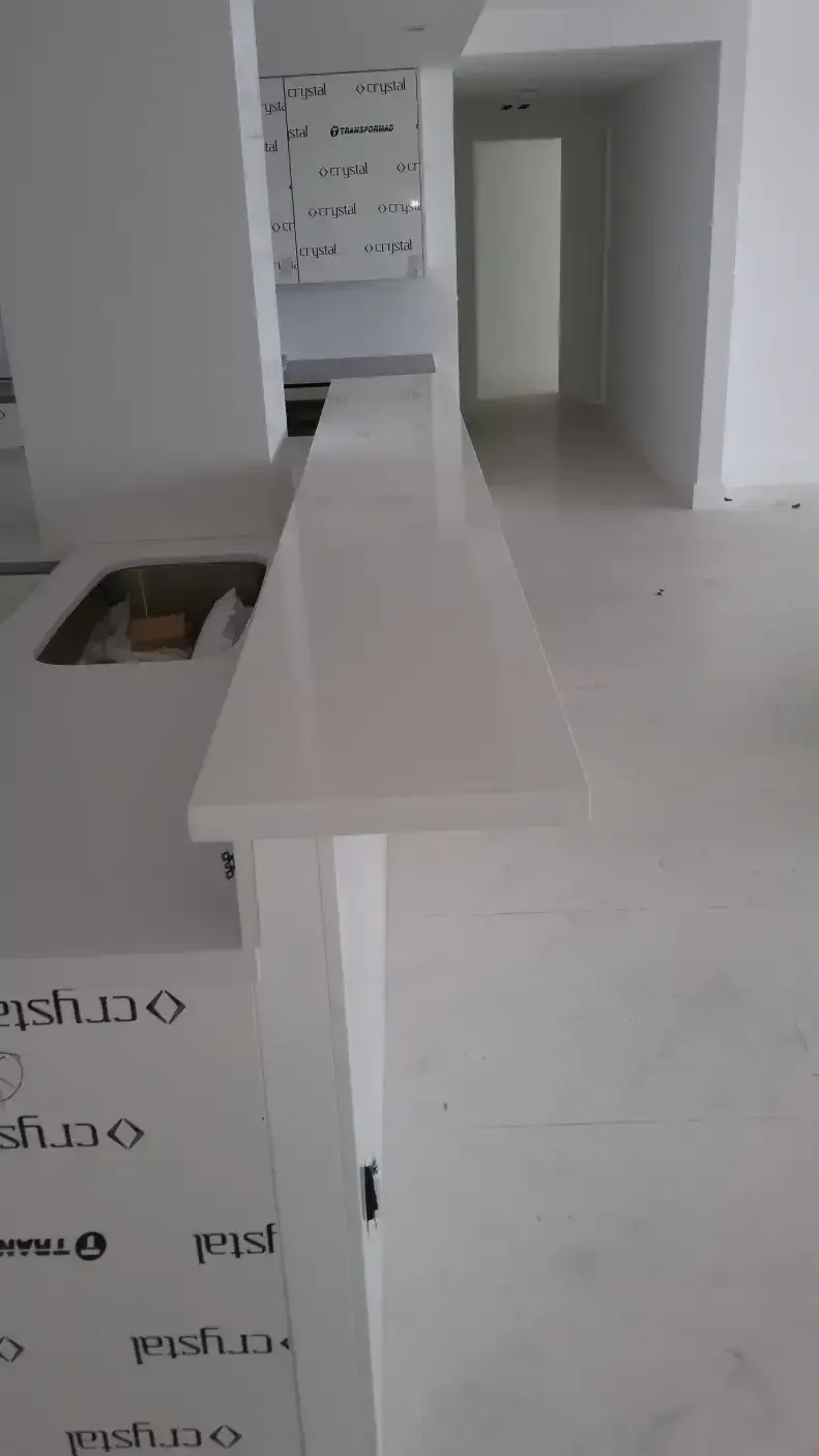 A kitchen with a long counter top and a sink.