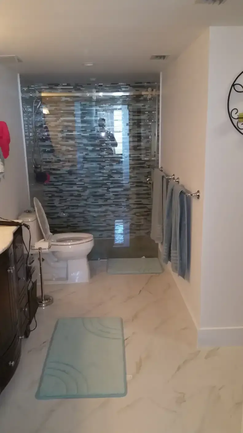A bathroom with a toilet , sink , and walk in shower.