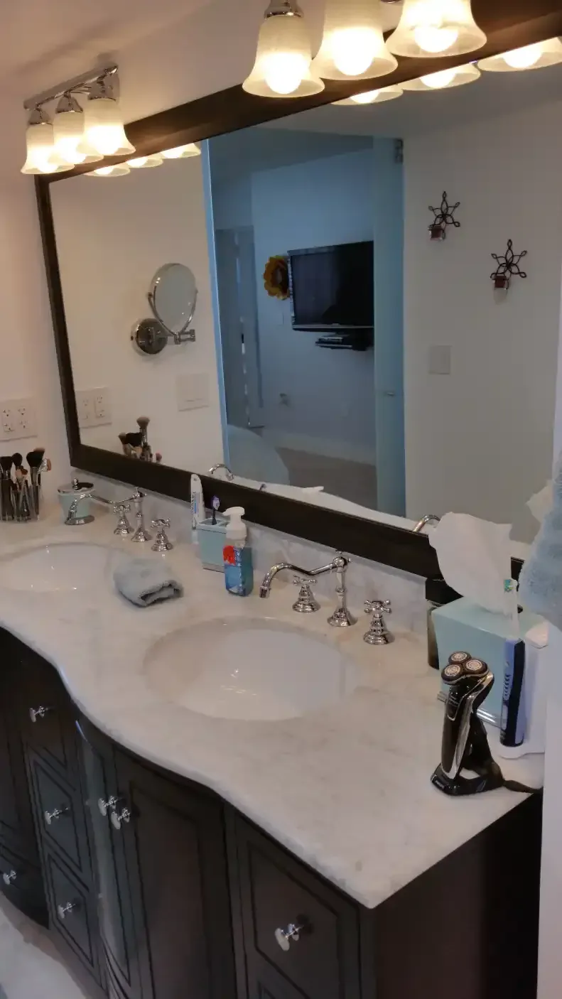 A bathroom with two sinks and a large mirror.