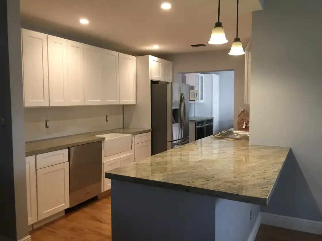 A kitchen with white cabinets and granite counter tops