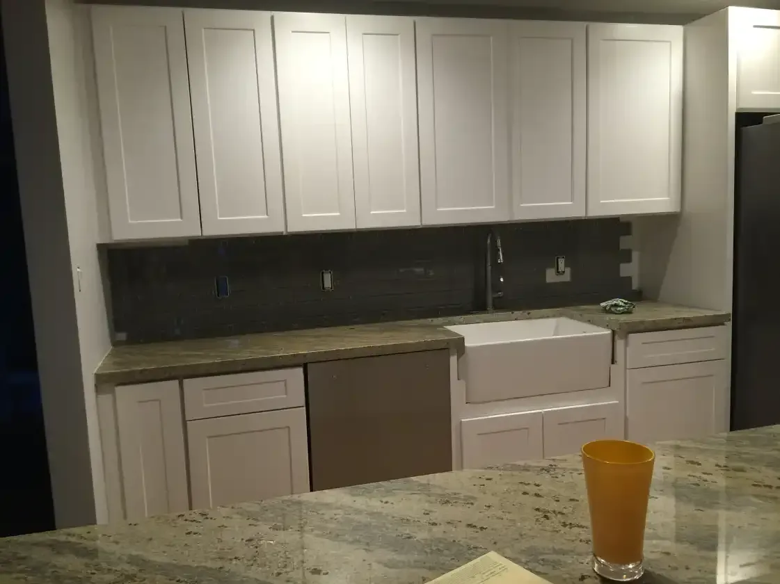 A kitchen with white cabinets and granite counter tops