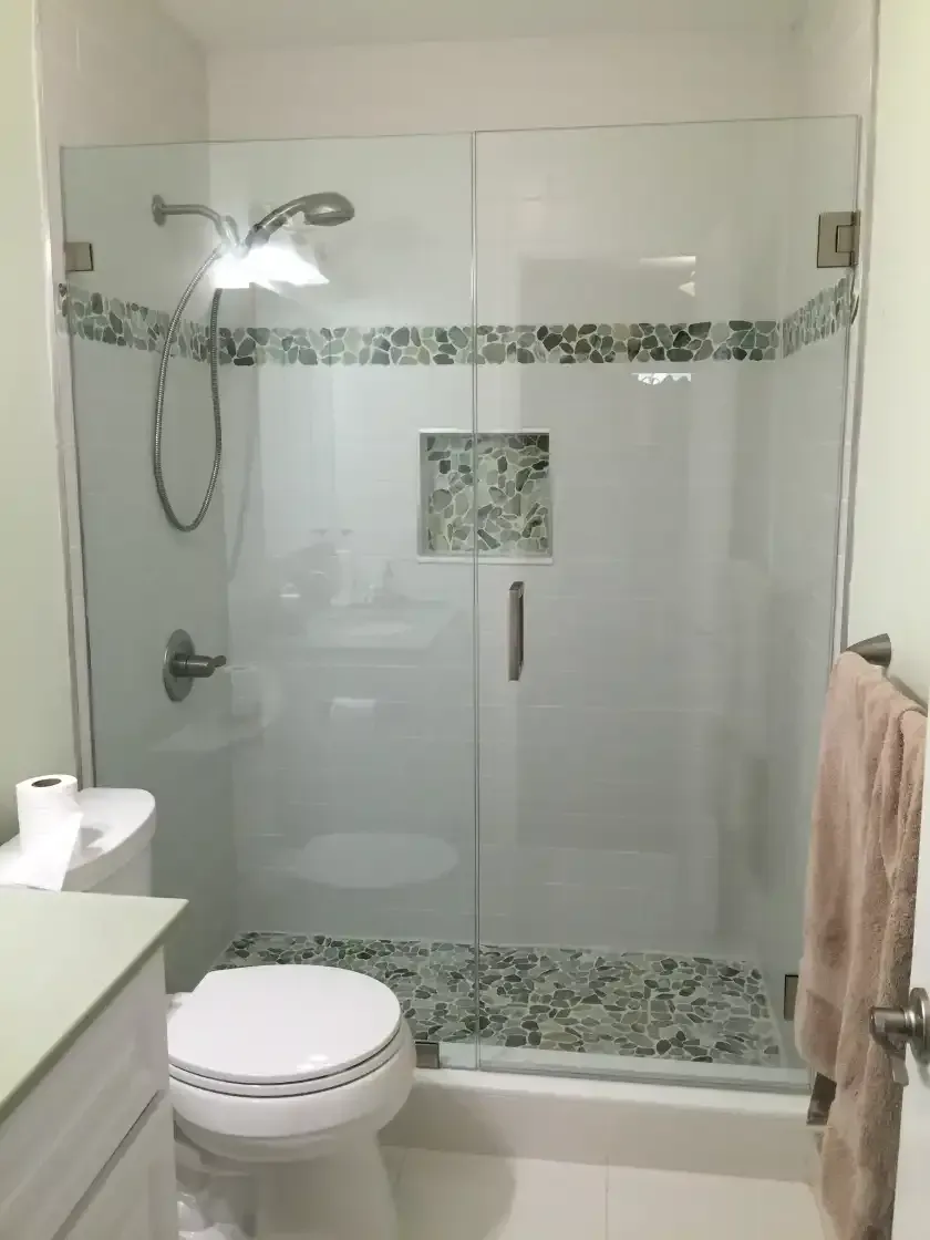 A bathroom with a toilet , sink and shower.