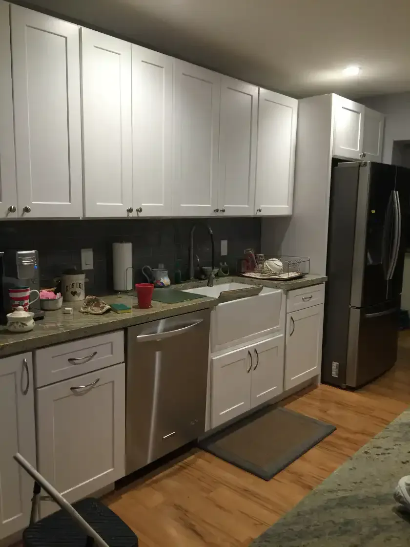 A kitchen with white cabinets and stainless steel appliances