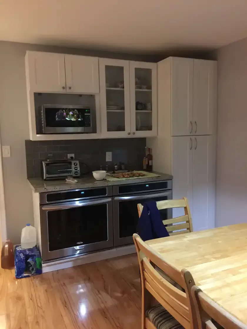 A kitchen with a table and chairs and a microwave