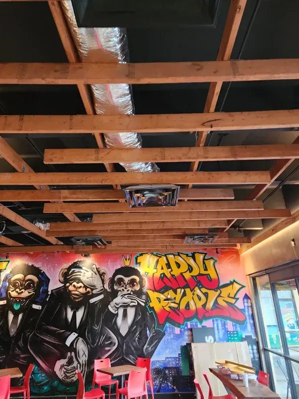 A restaurant with a mural of three monkeys on the wall.
