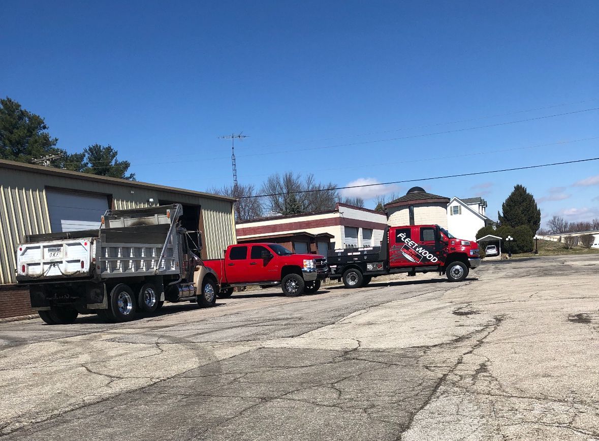 Trucks Are Parked In Front Of A Building | Southern, IN | OK&A Fleetwood Asphalt Concrete Raising