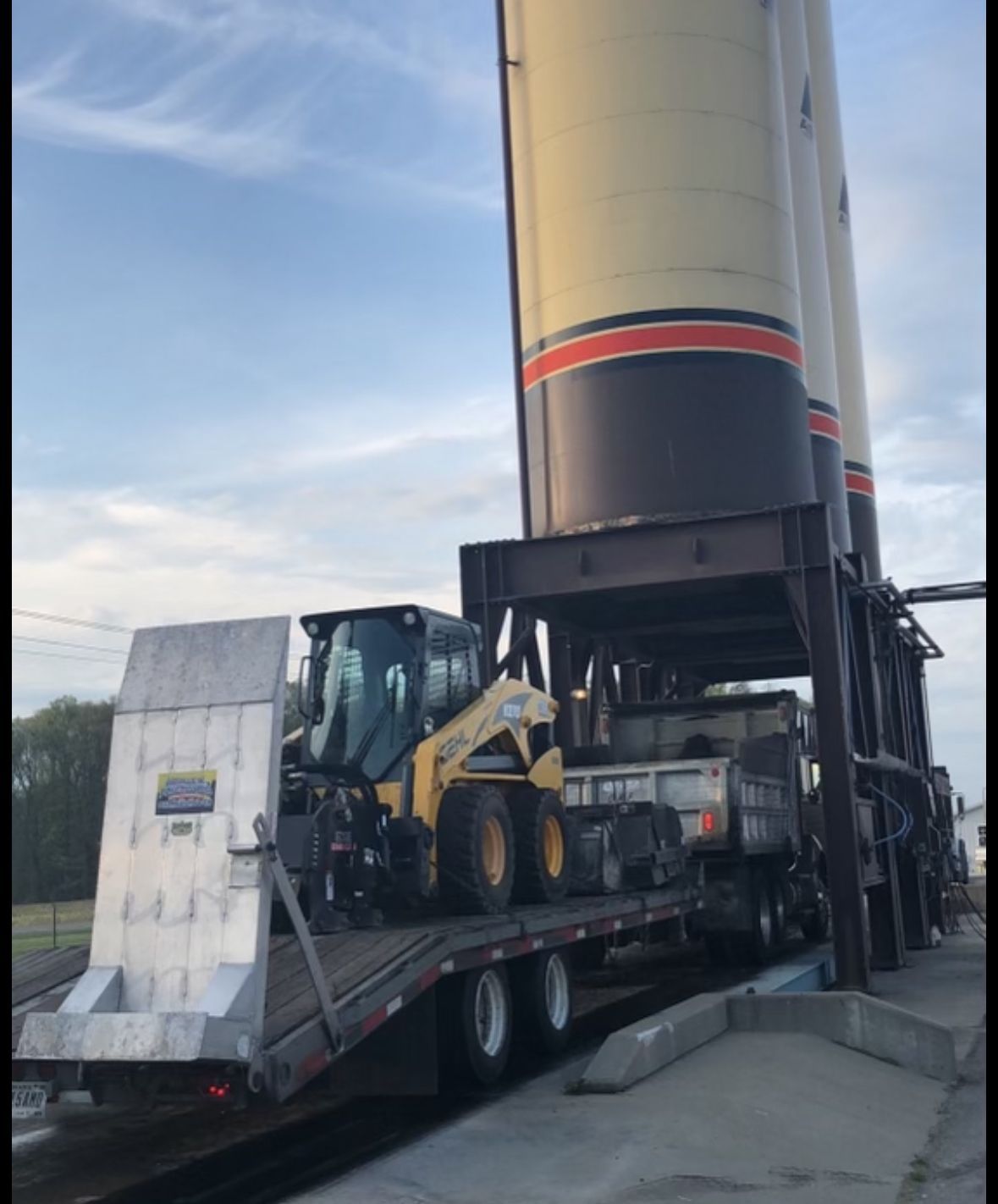 A Skid Steer Is On The Back Of A Flatbed Truck | Southern, IN | OK&A Fleetwood Asphalt Concrete Raising