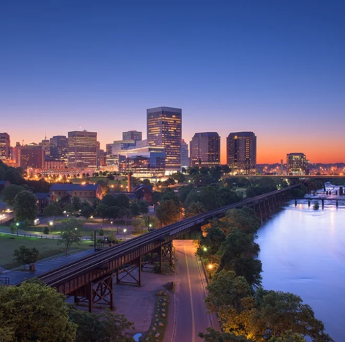 Skyline of Richmond, Virginia at dusk; buildings and bridge over the James River.