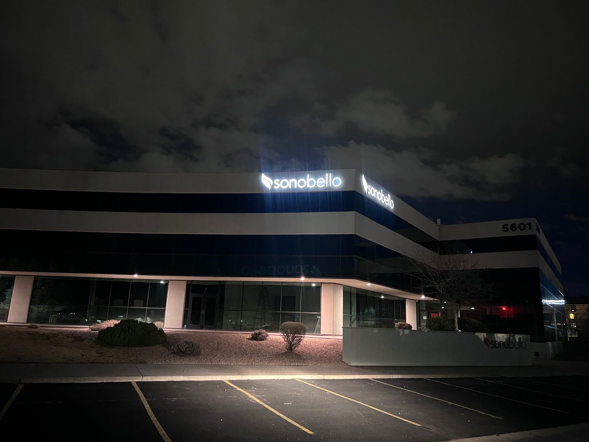 A large building with a lot of windows is lit up at night.