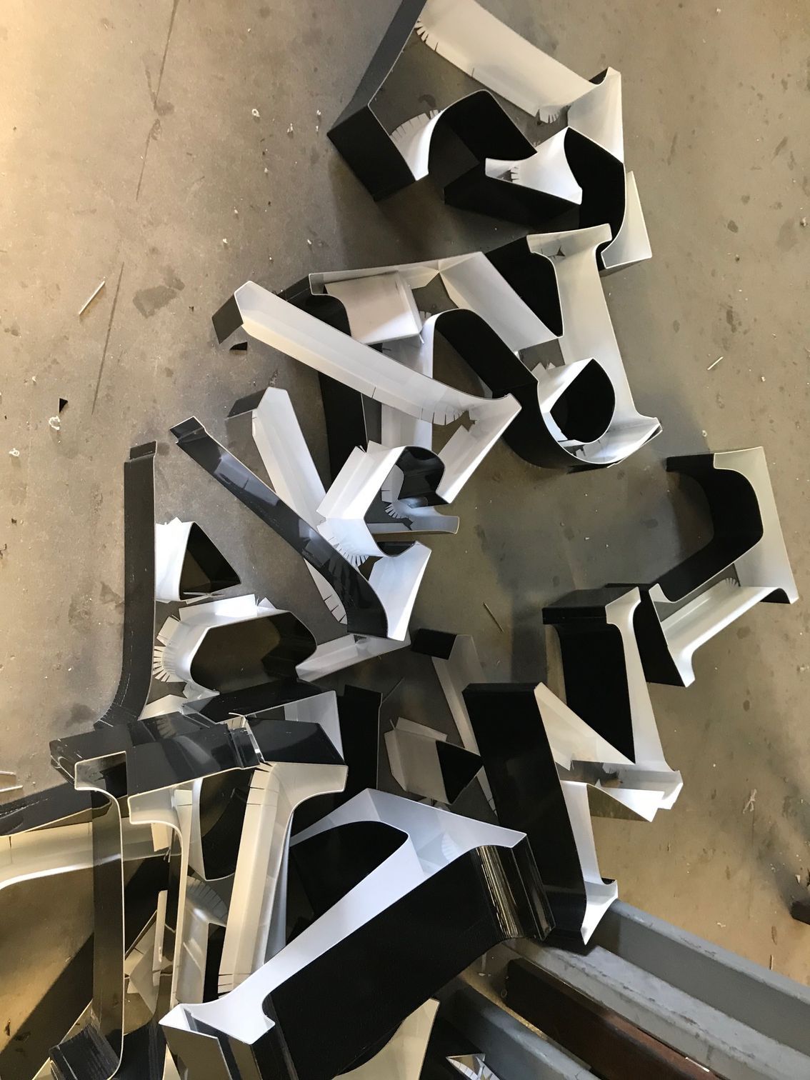 A bunch of metal letters are laying on the floor