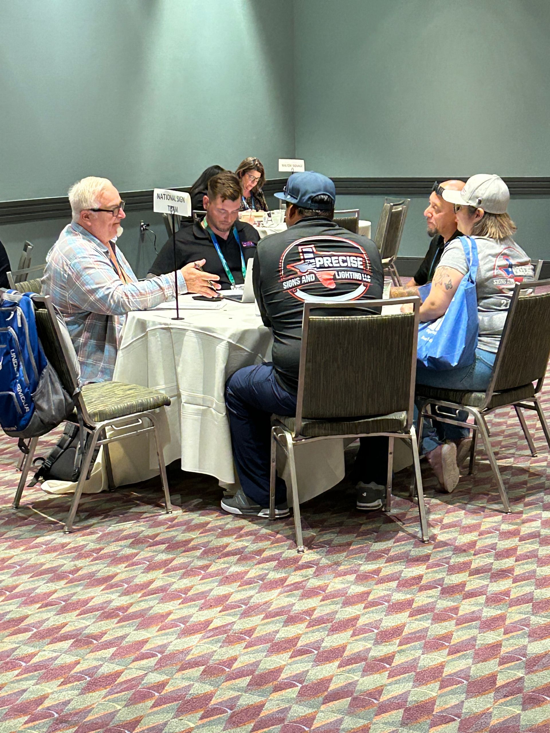 A group of people are sitting around a table in a room.