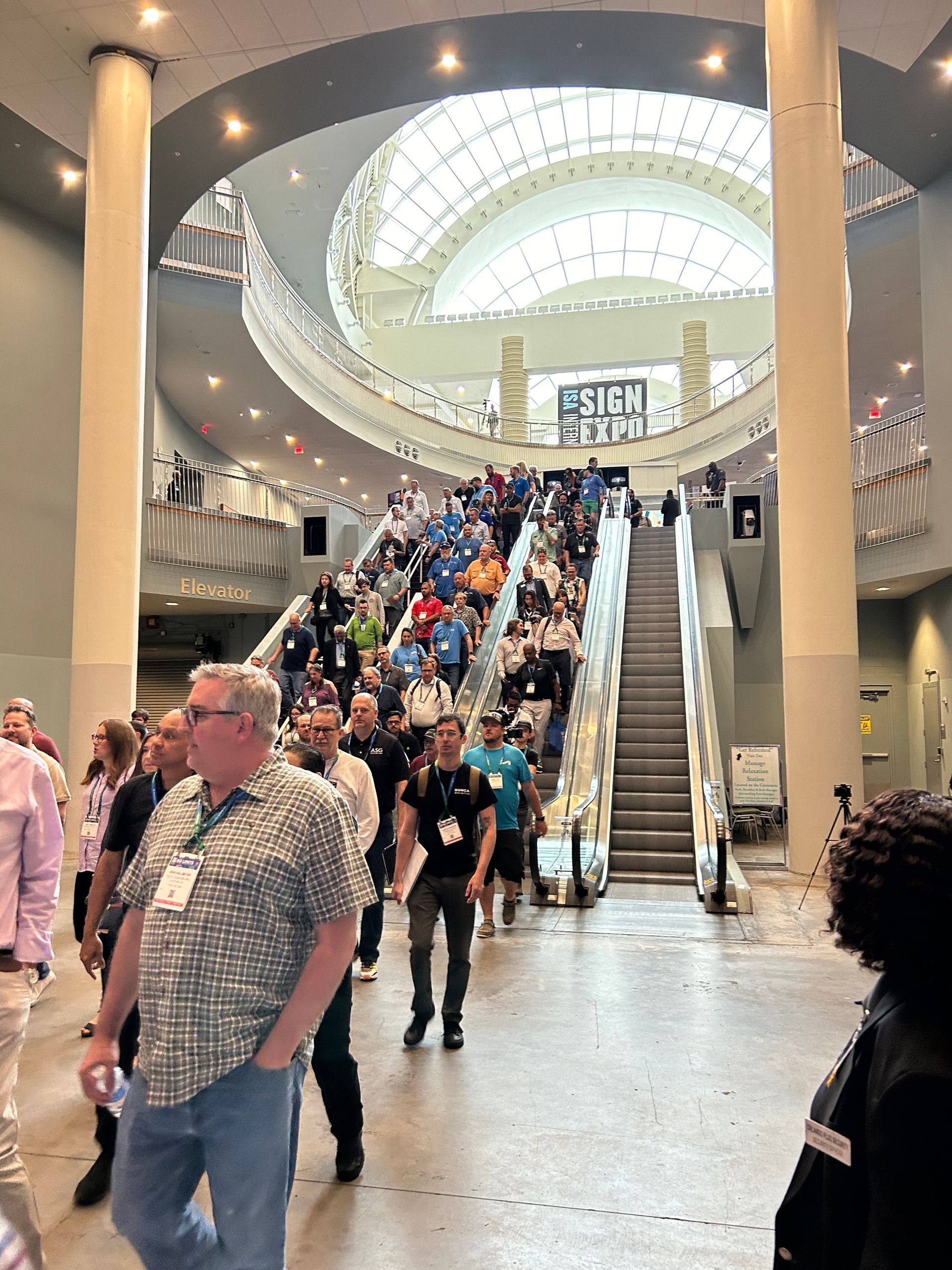 A group of people are walking down an escalator in a large building