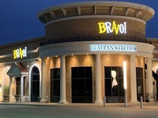 A bravo italian kitchen restaurant is lit up at night