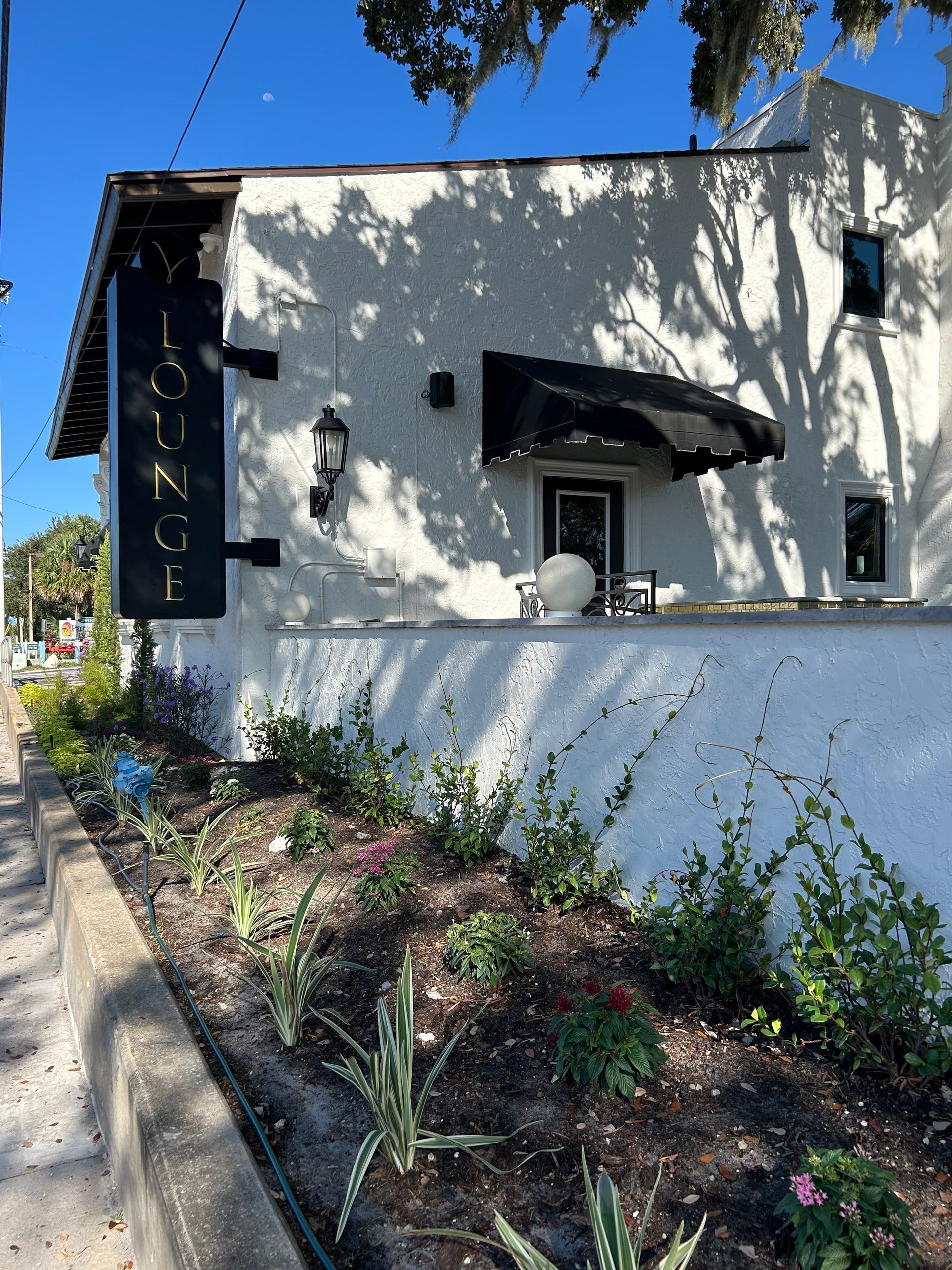 A white building with a black awning and a sign that says 1222