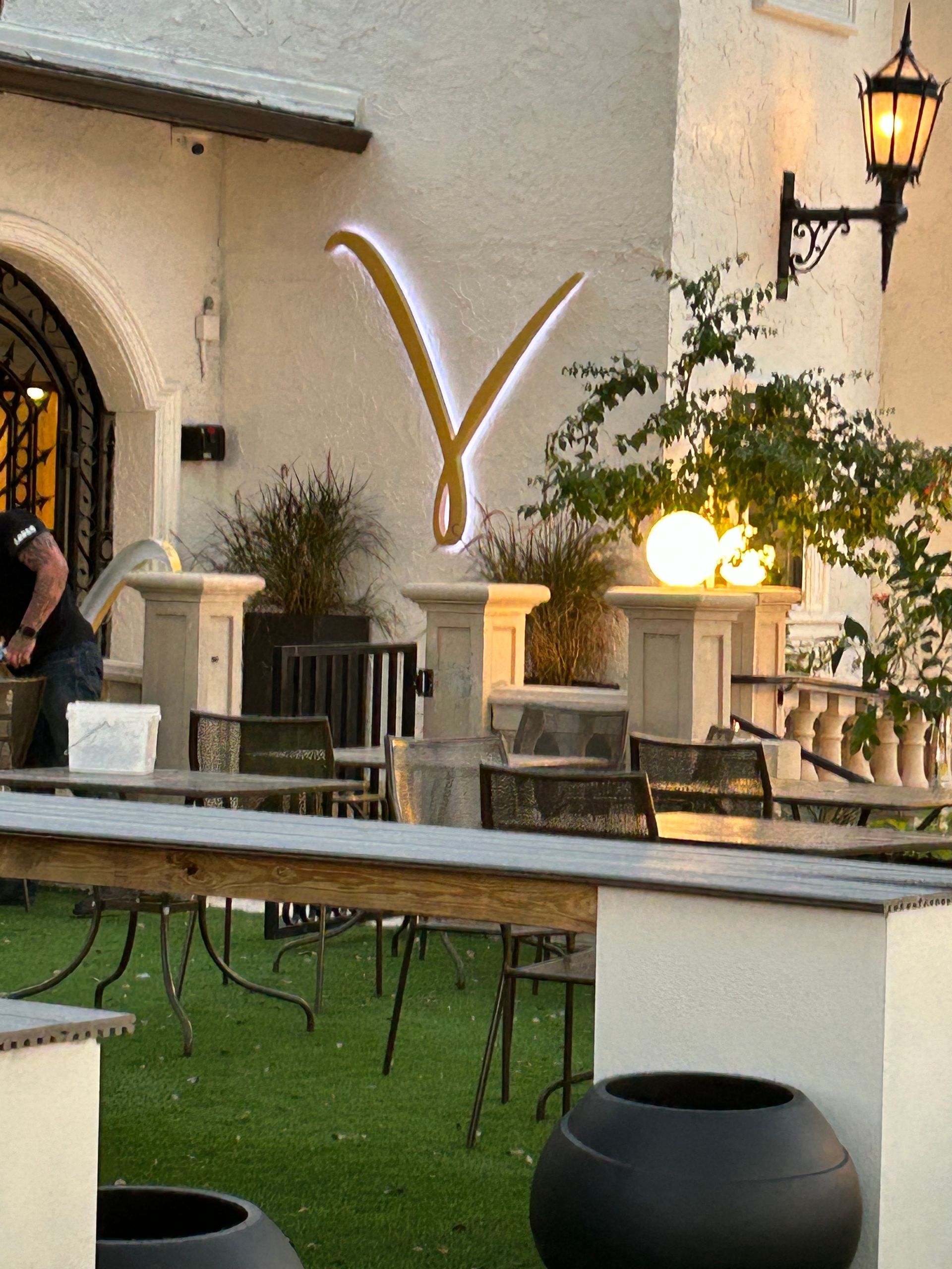A man is standing in front of a building with a sign that says y on it