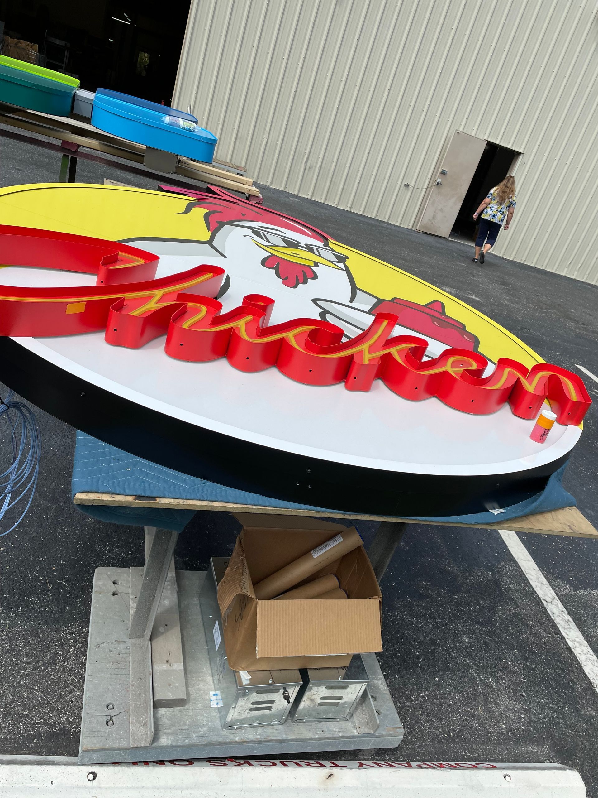 A chicken restaurant sign is sitting on top of a table.