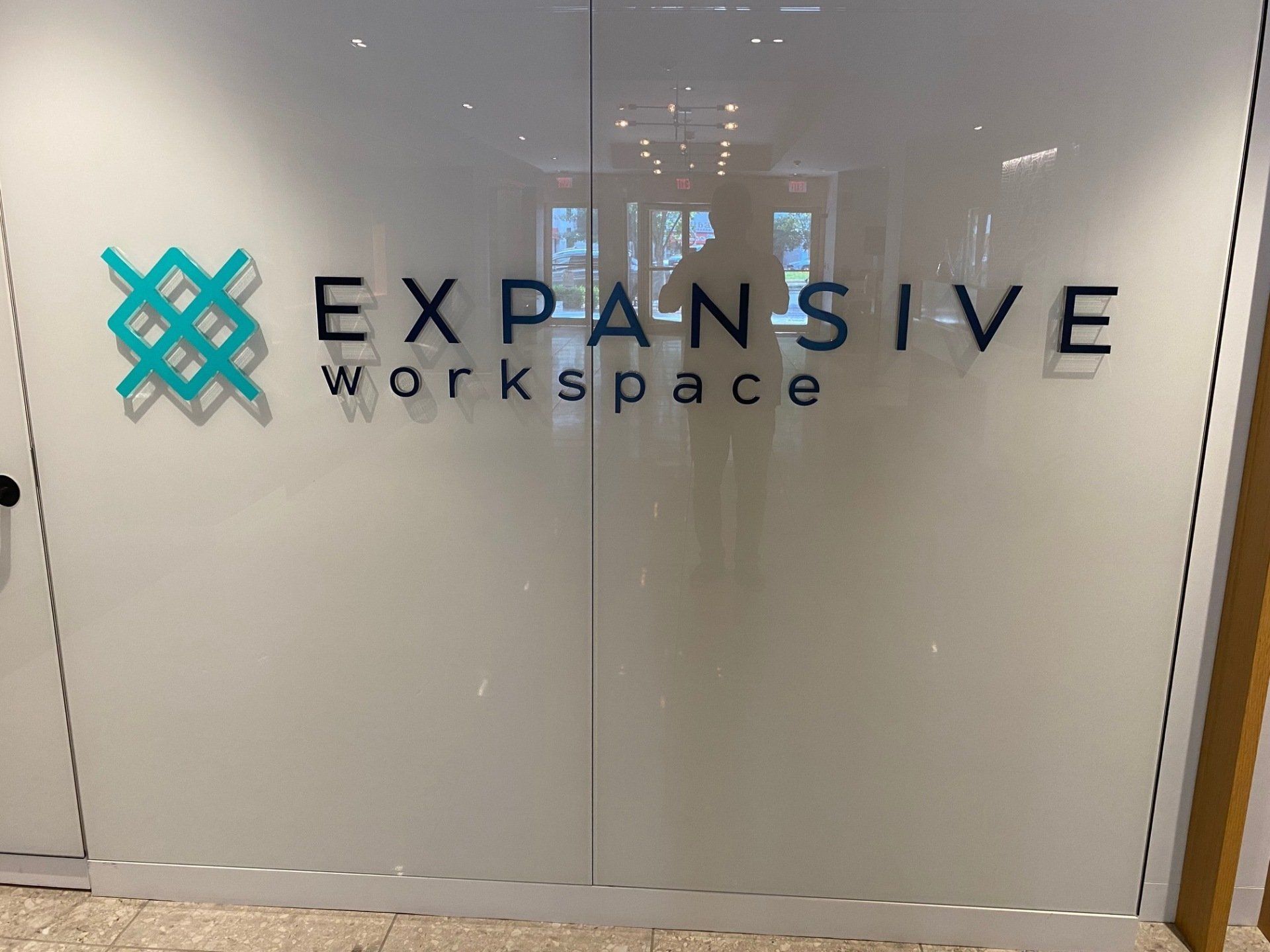 A sign on a glass door that says expansive workspace