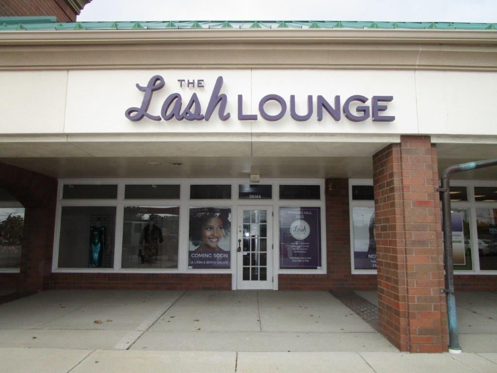 The lash lounge is located in a brick building