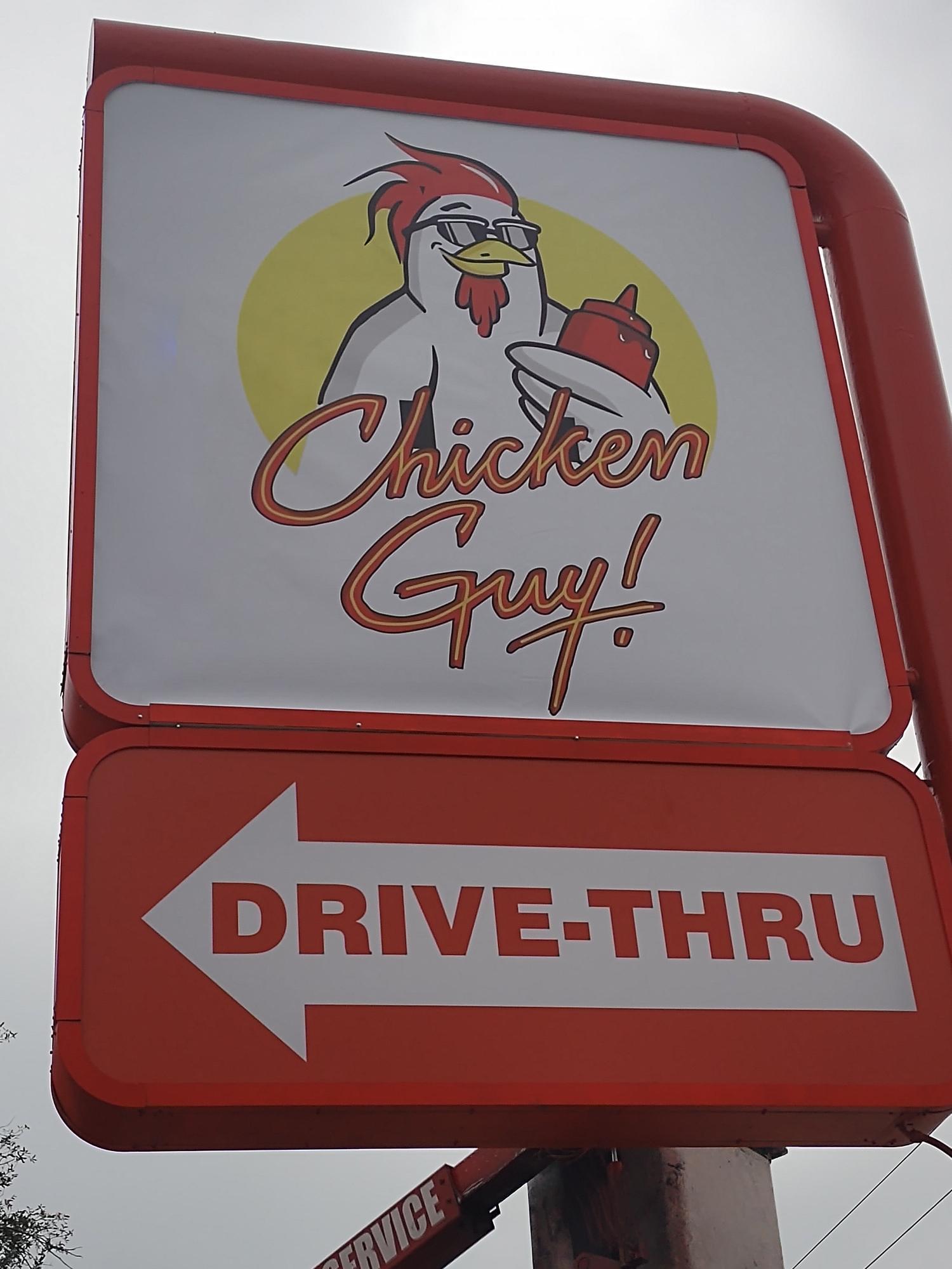 A chicken guy drive thru sign with an arrow pointing to the right
