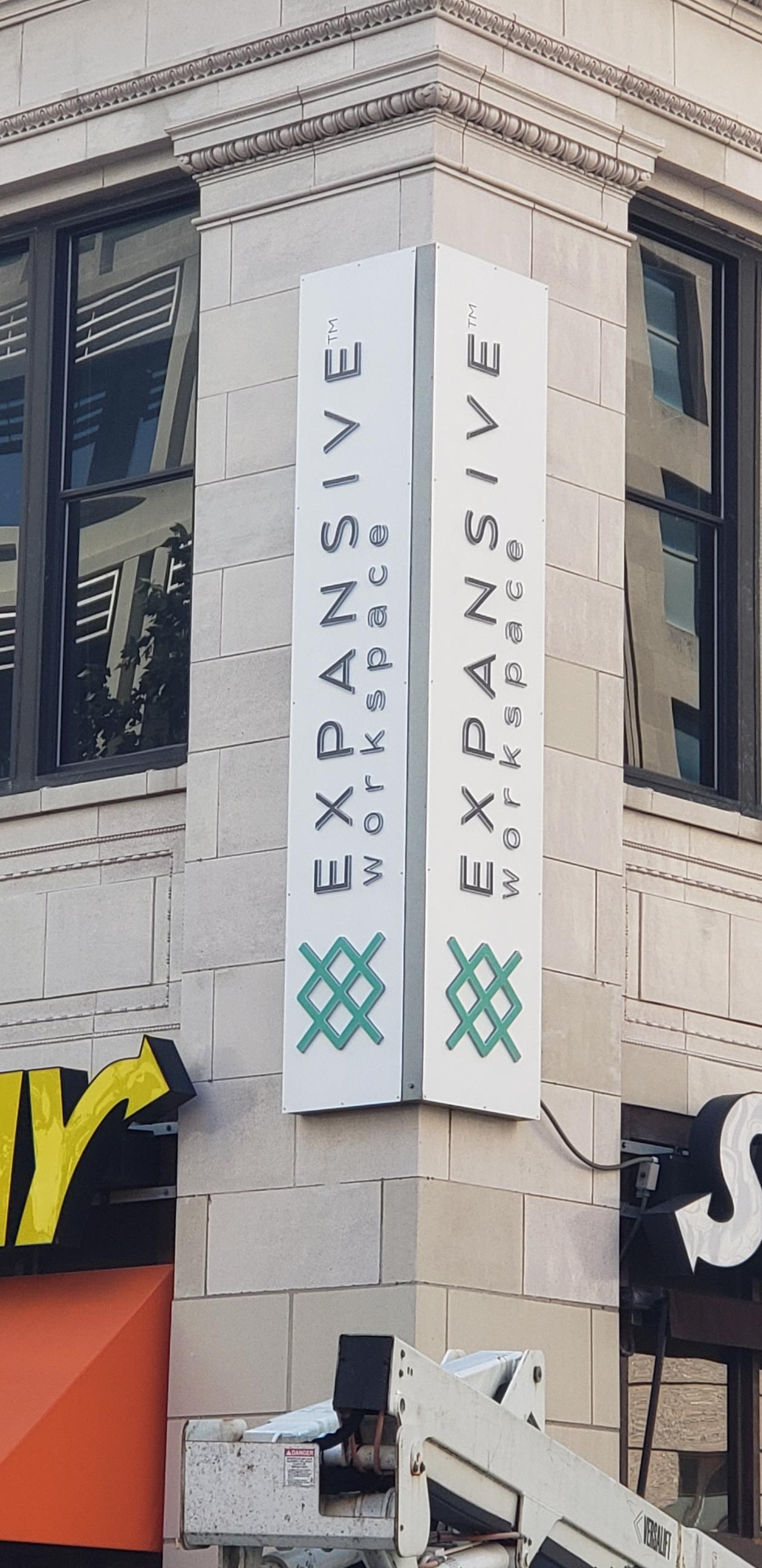 A sign on the side of a building that says expansive workspace