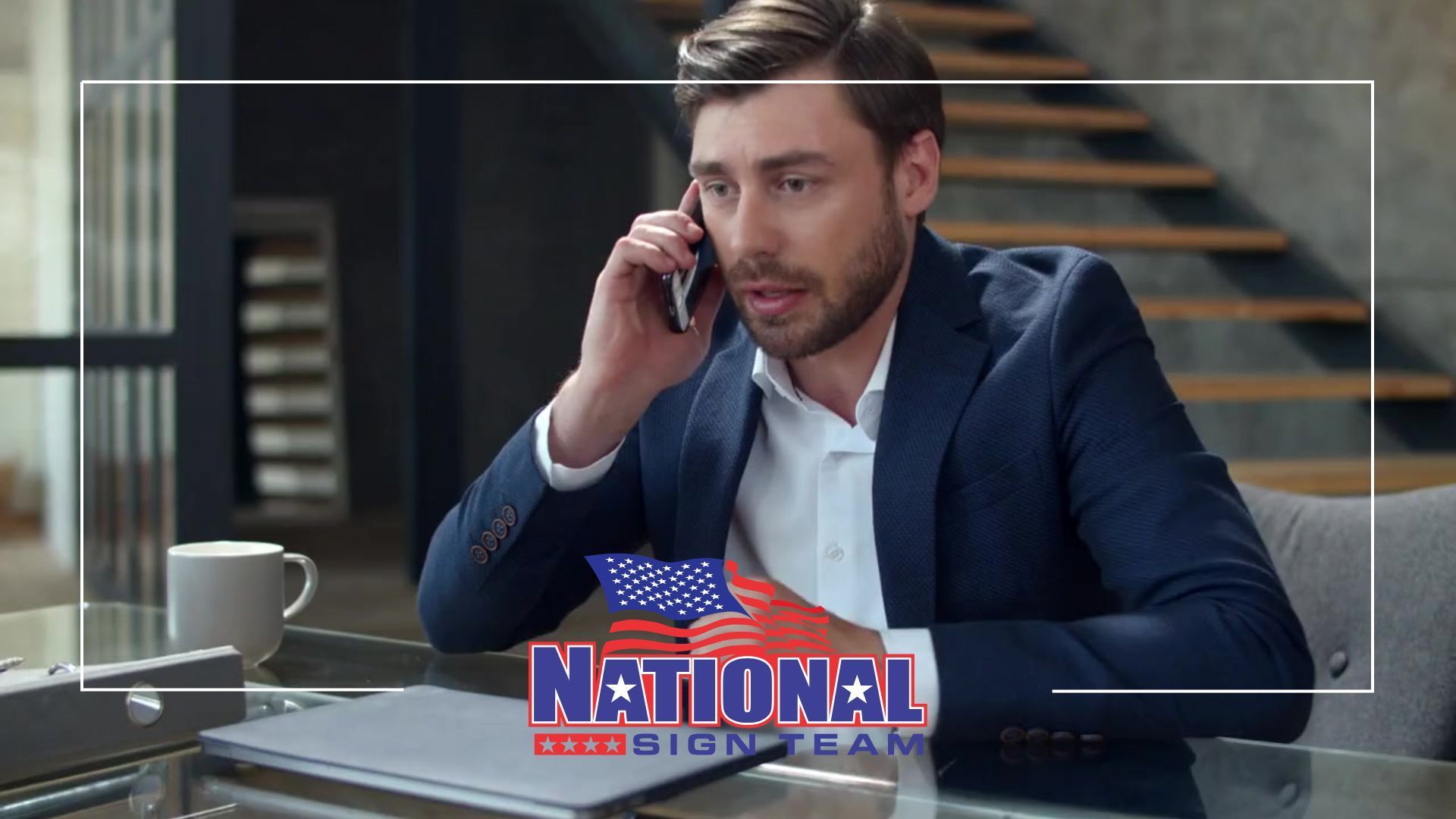 A man in a suit is sitting at a table talking on a cell phone.