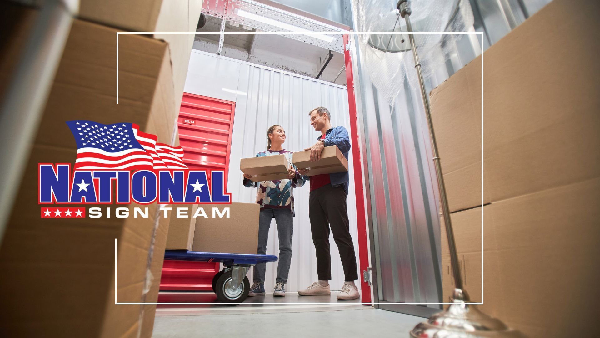 A man and a woman are standing in a warehouse holding boxes.