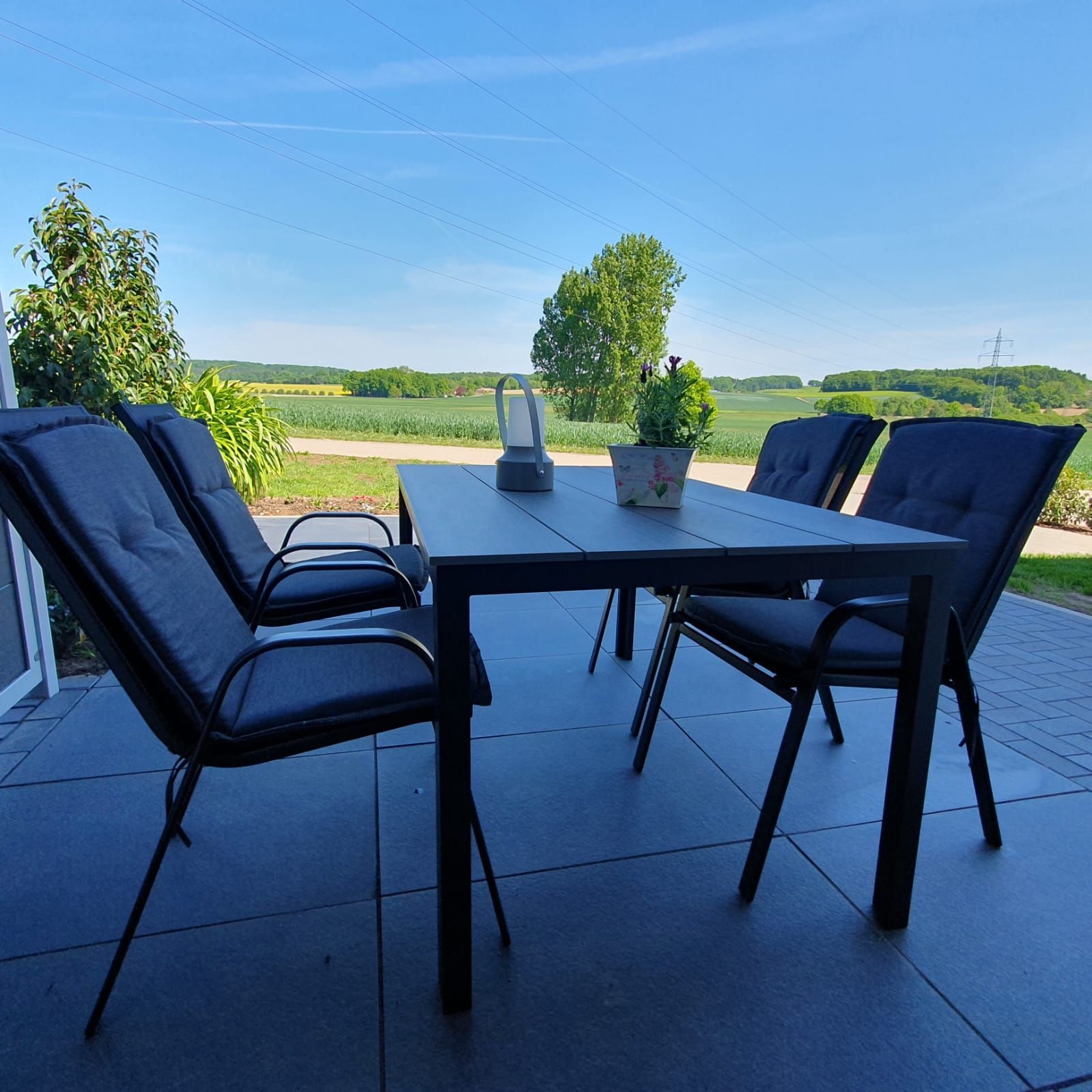 Terrasse mit Tisch und Blick über die Felder – Ferienwohnung Haus Ossenbrock in Bissendorf
