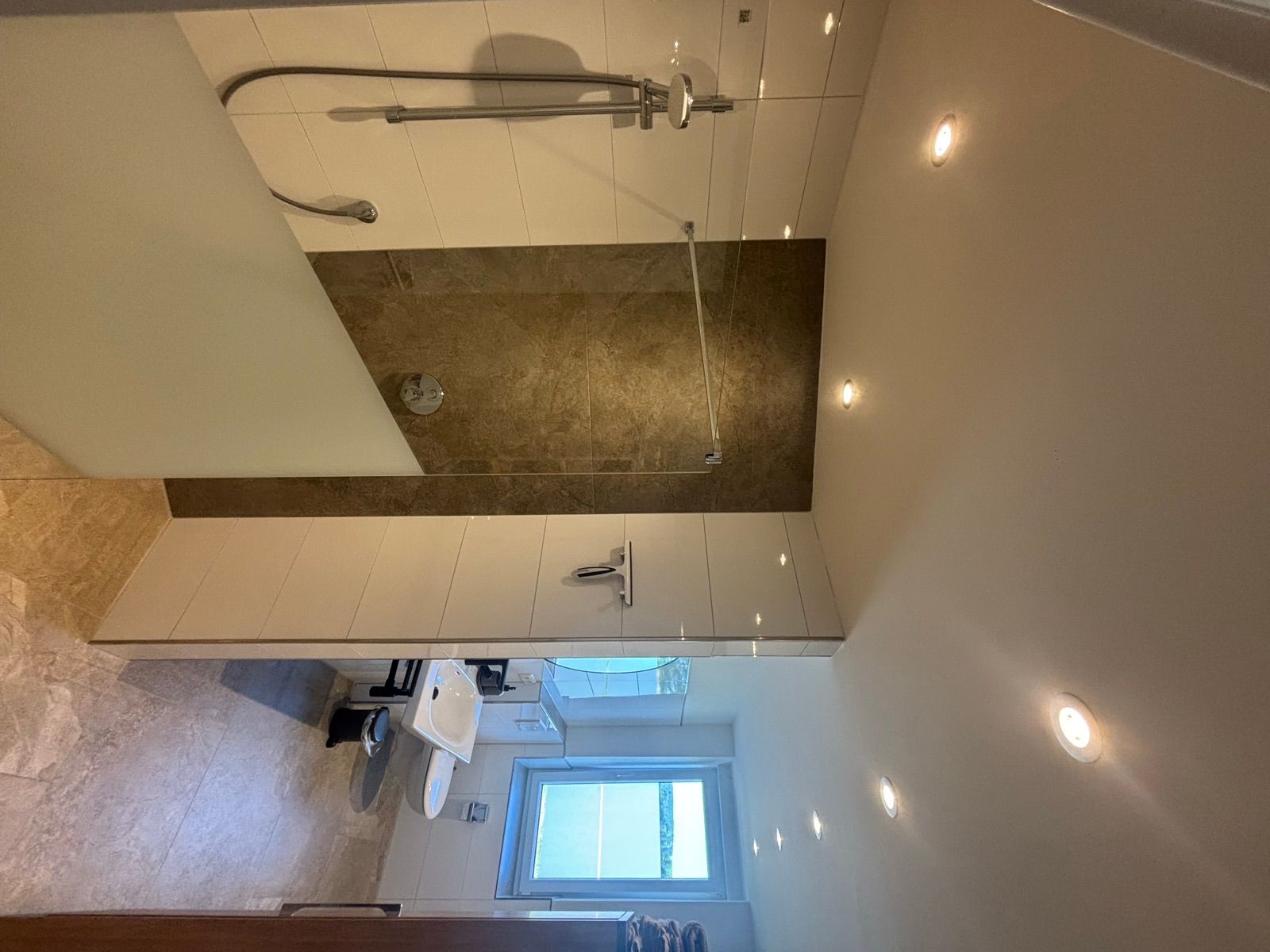 Modernes Badezimmer mit ebenerdiger Dusche, Waschbecken und WC der Ferienwohnung Haus Ossenbrock