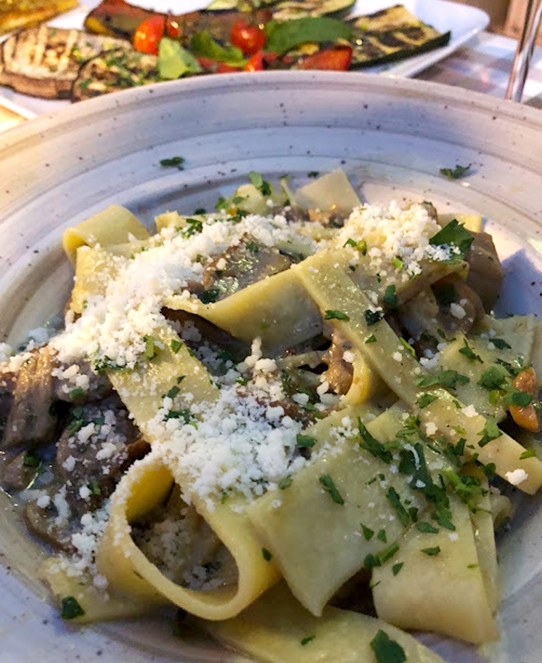 Un primo piano di un piatto di pasta con funghi e formaggio