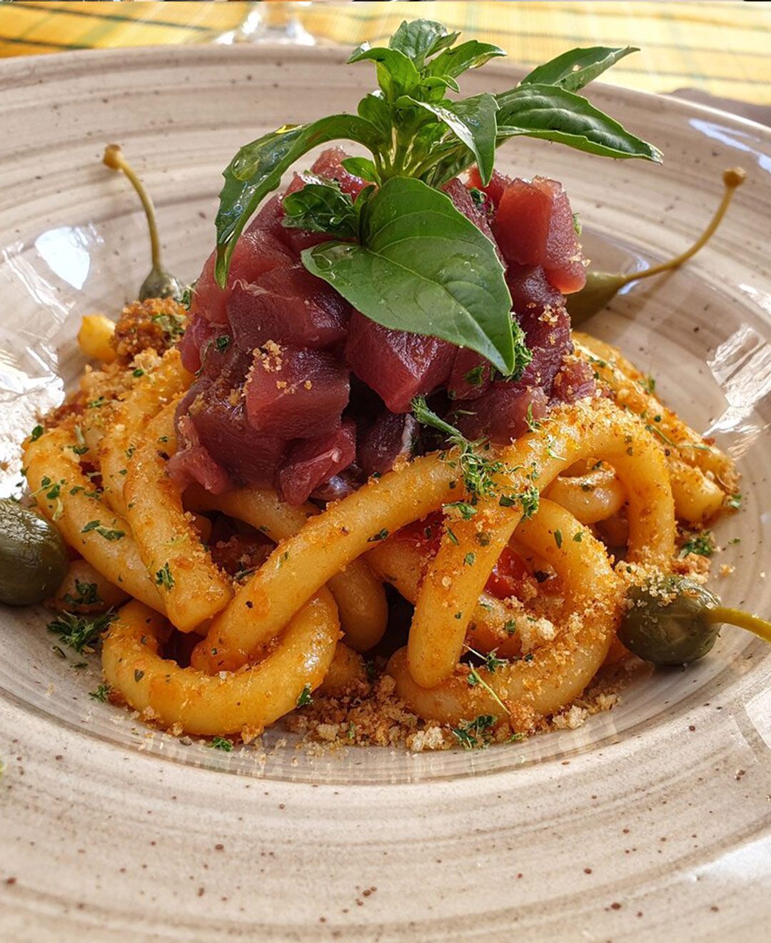Un primo piano di un piatto di pasta con carne e verdure su un tavolo.