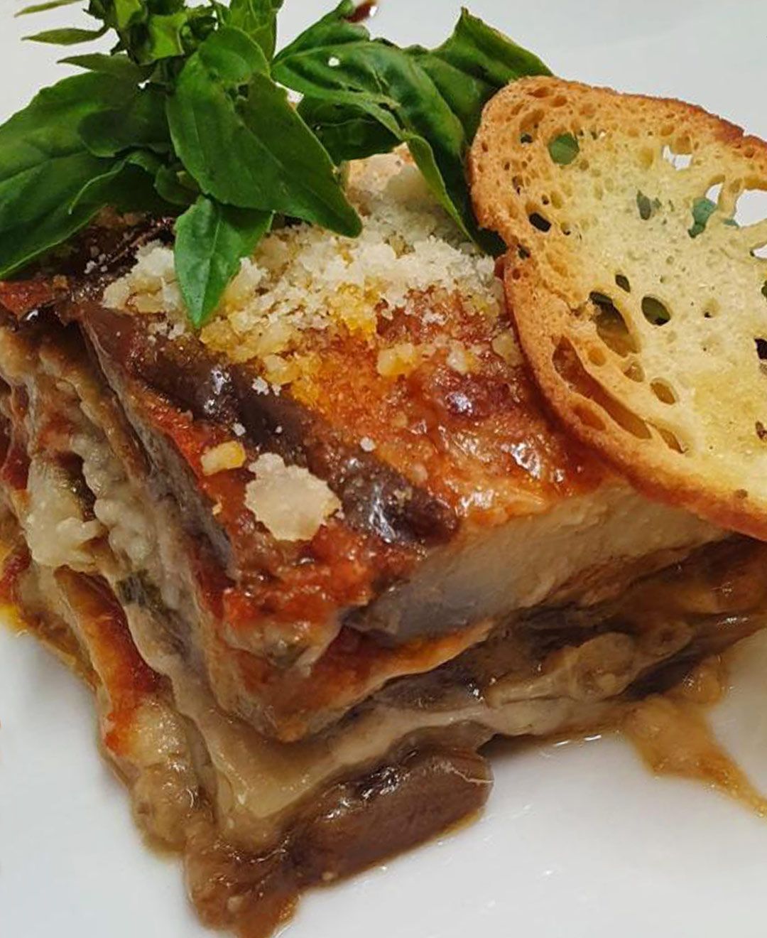 Un primo piano di una lasagna su un piatto bianco