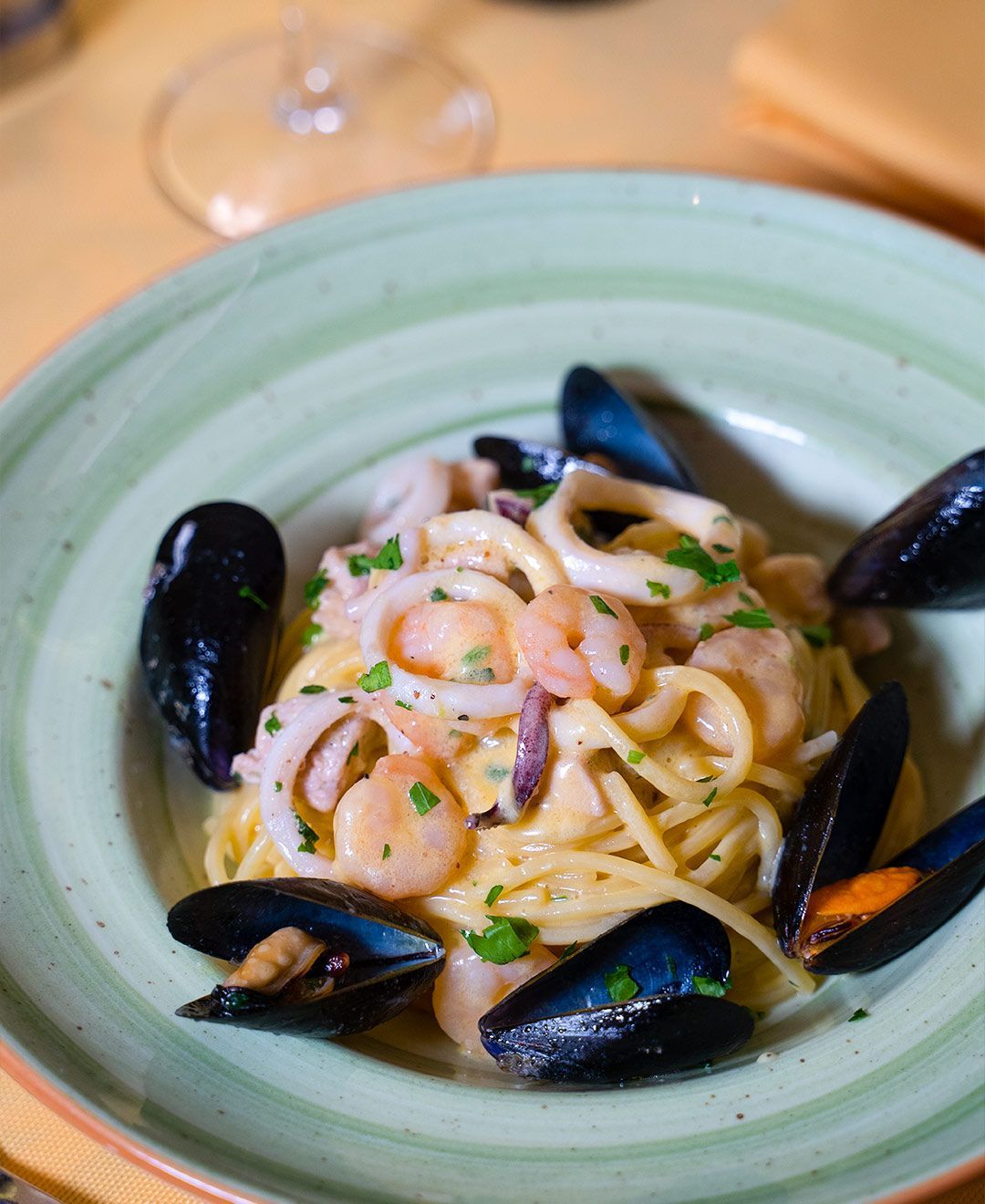 Un piatto di spaghetti ai frutti di mare e cozze su un tavolo.