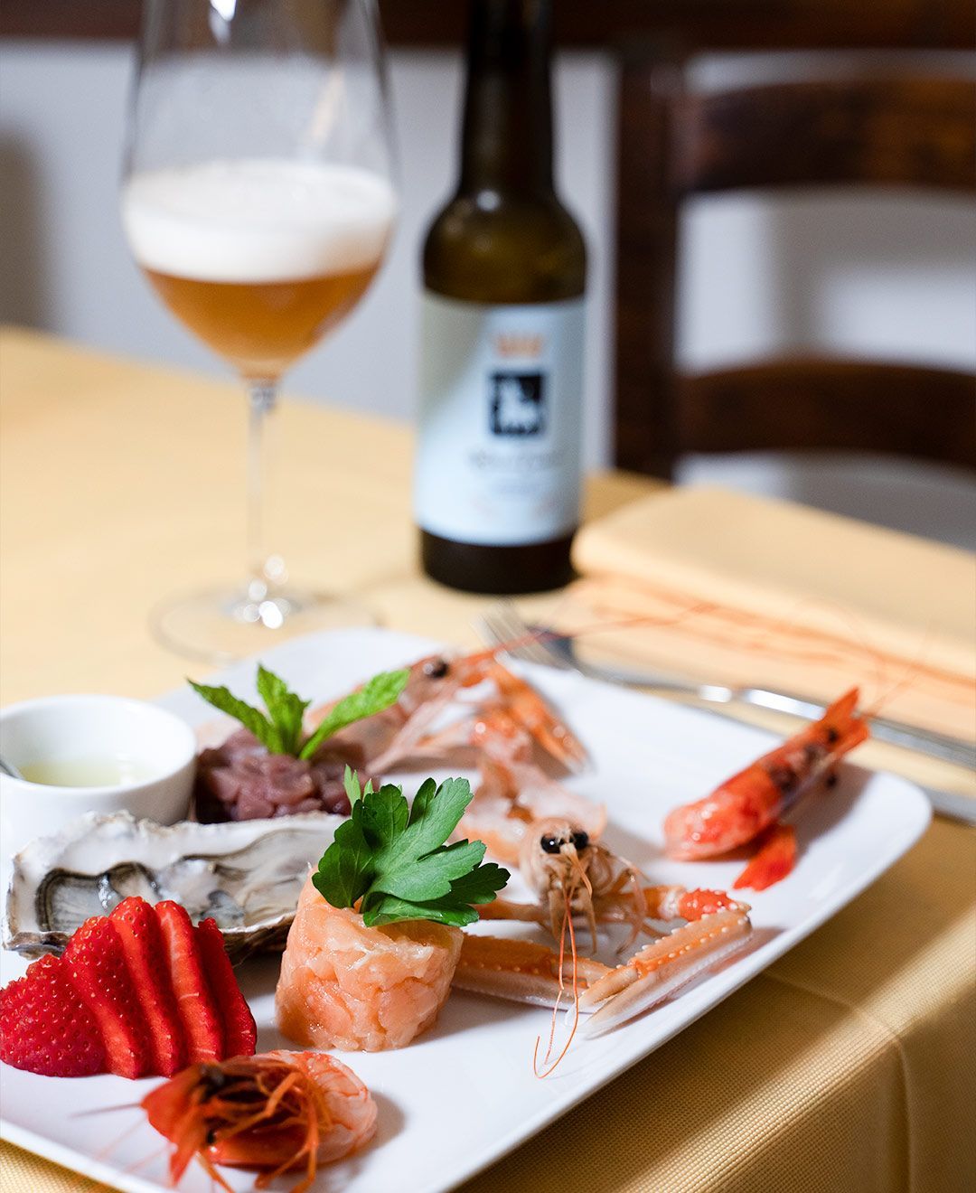 Un piatto di cibo con una bottiglia di birra sullo sfondo