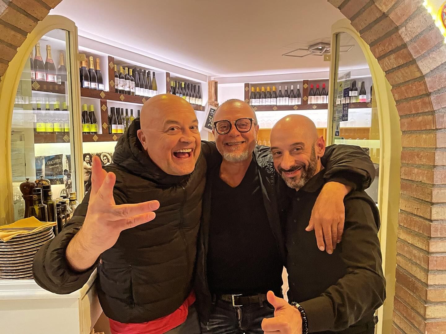 Tre uomini calvi posano per una foto in un ristorante.