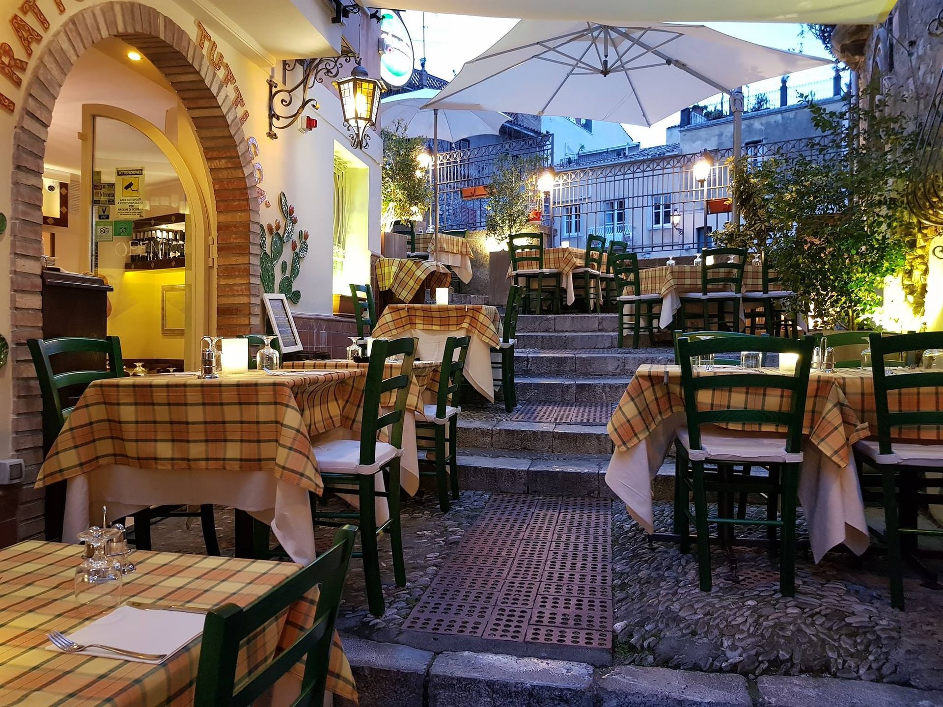 Tavoli e sedie all'esterno di un ristorante con ombrelloni