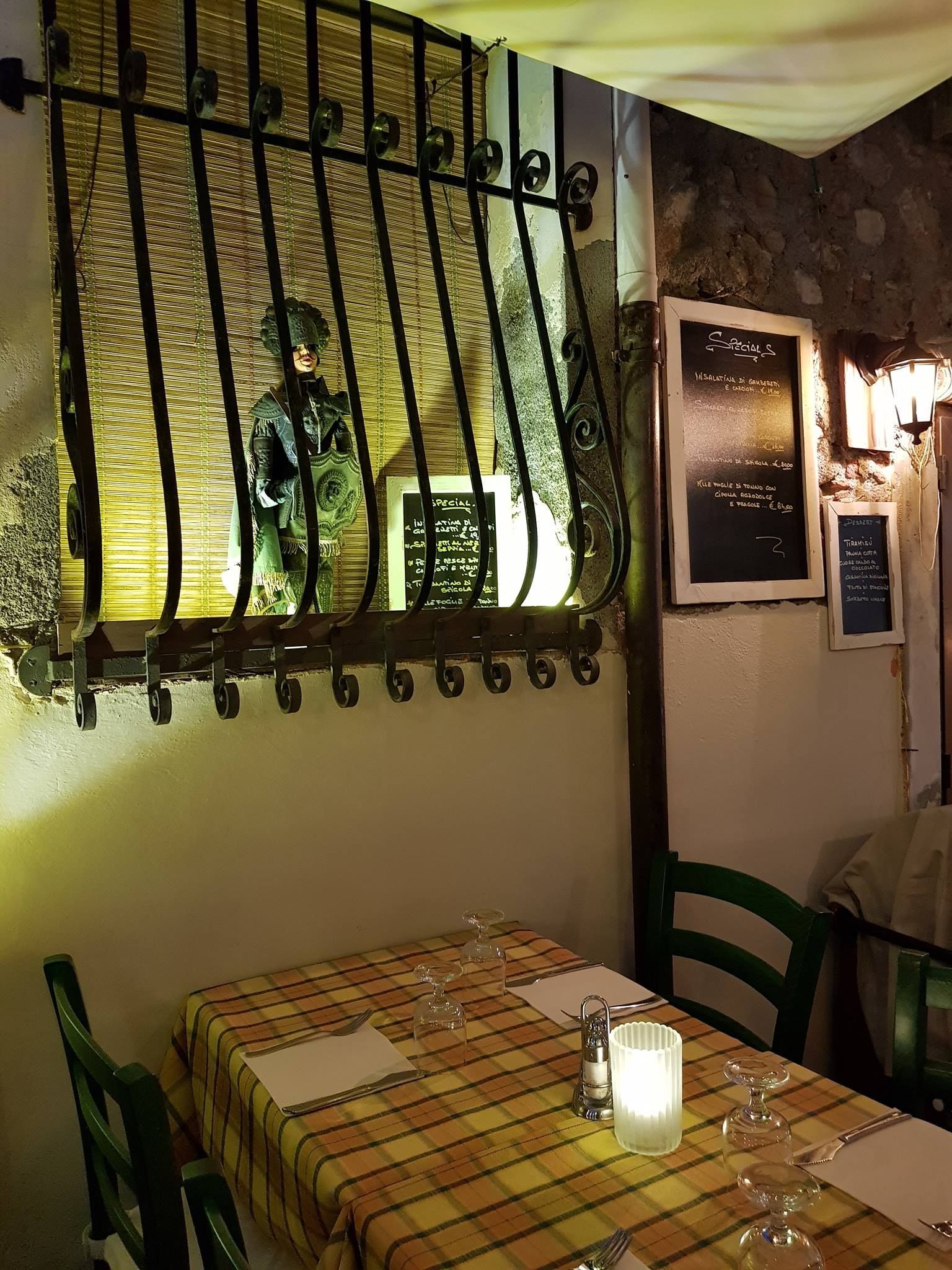 Un ristorante con un tavolo e delle sedie e un cartello sul muro