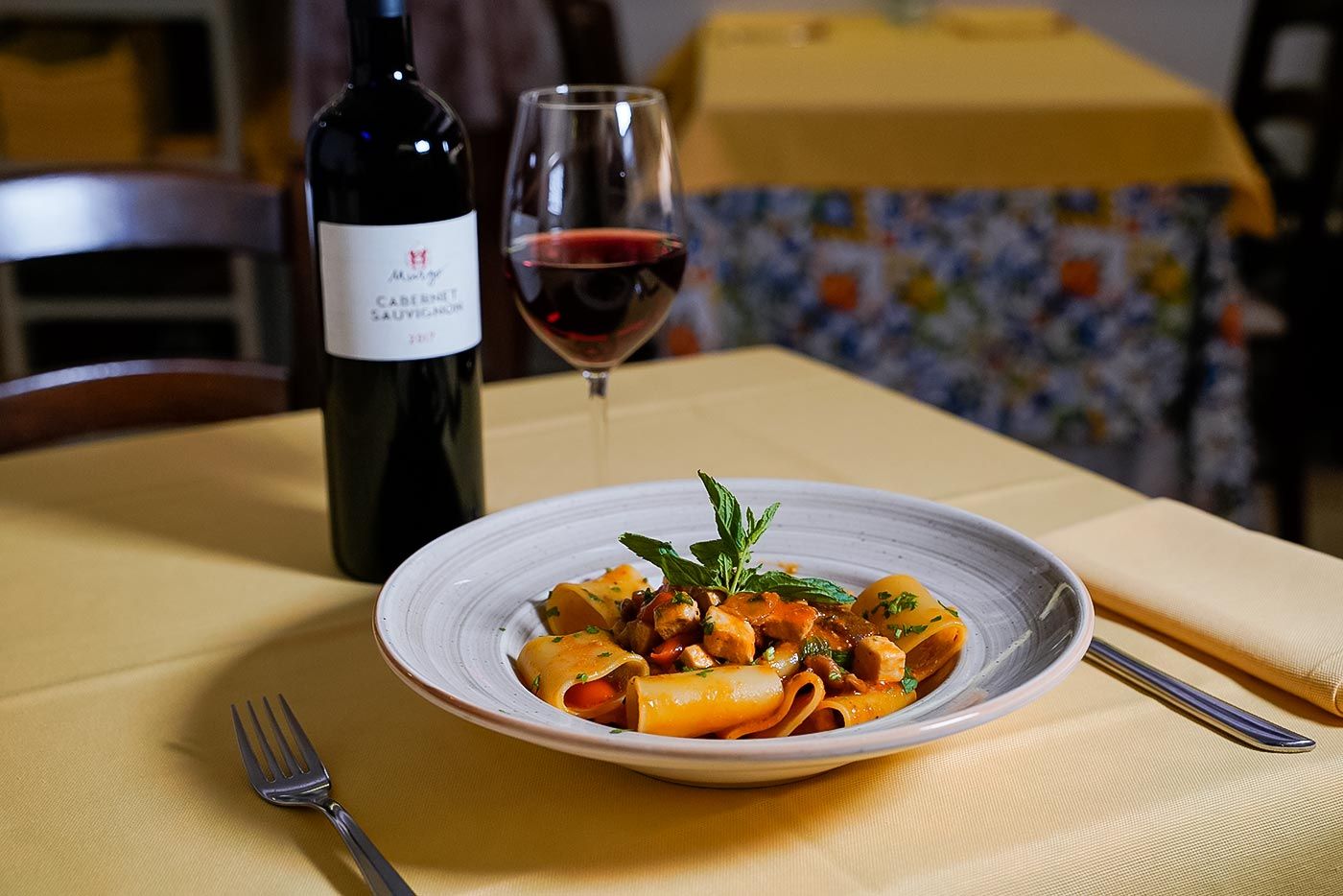 Un piatto di pasta e un bicchiere di vino su un tavolo.