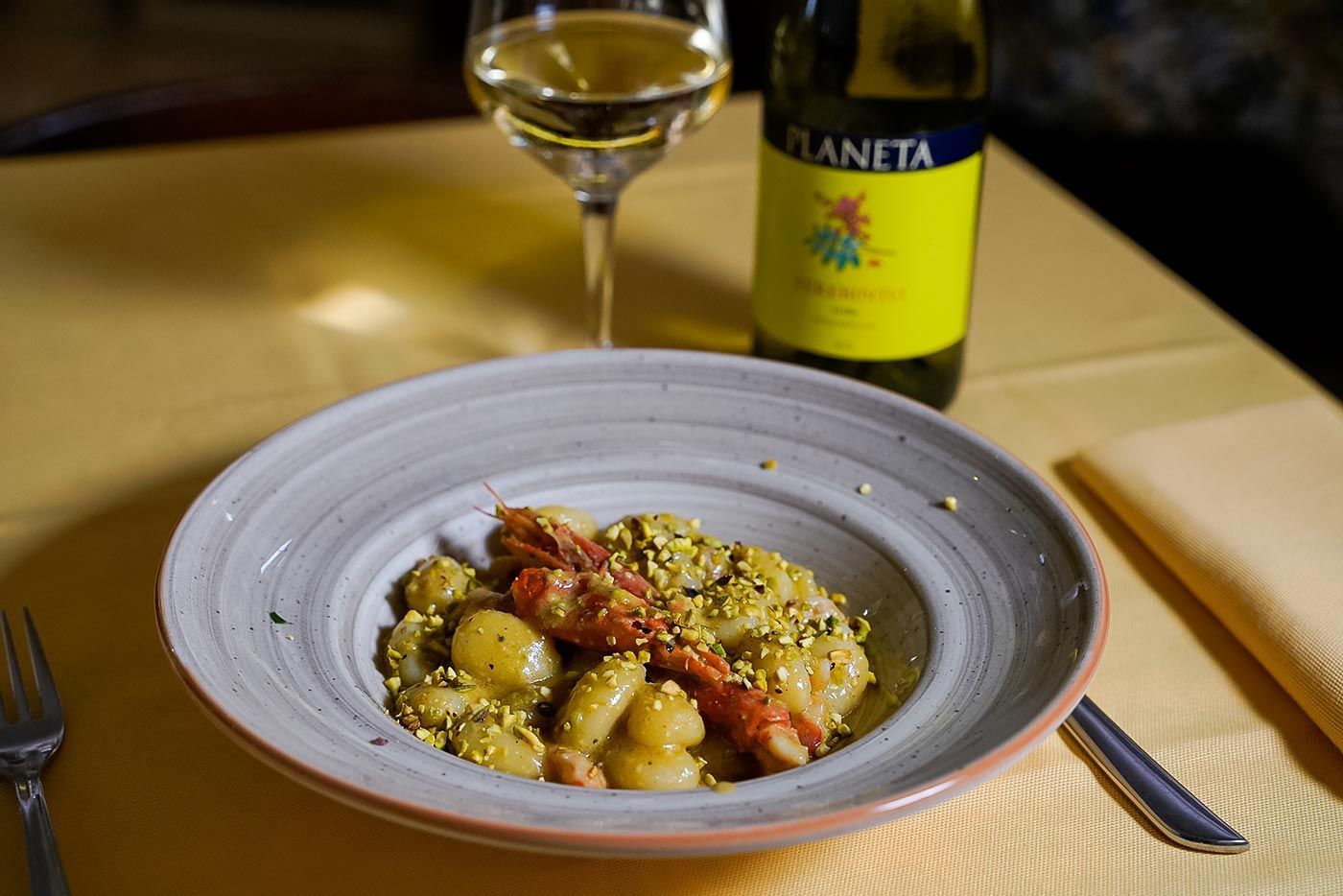 Un piatto di cibo e una bottiglia di vino su un tavolo.