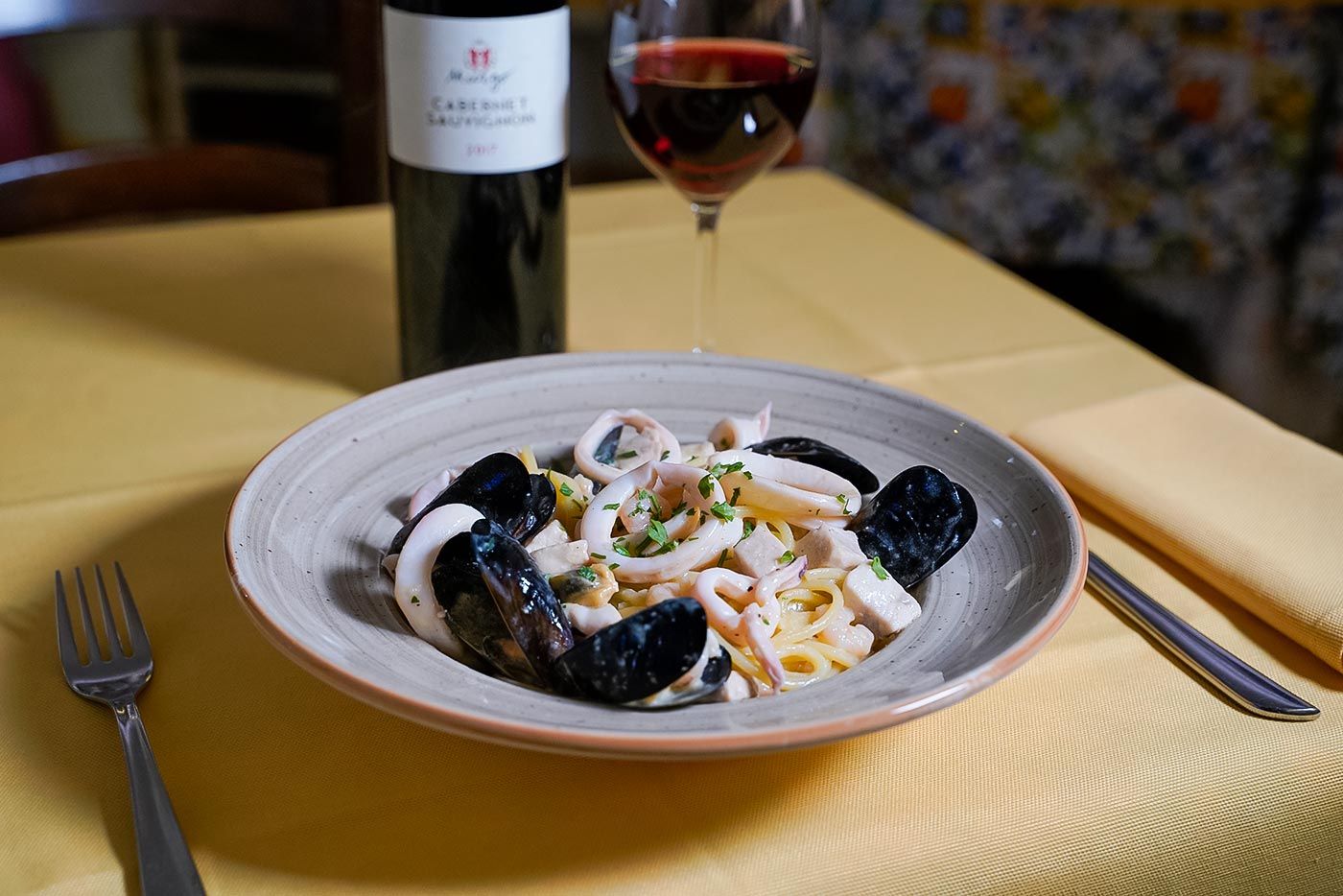 Un piatto di cibo e un bicchiere di vino su un tavolo.