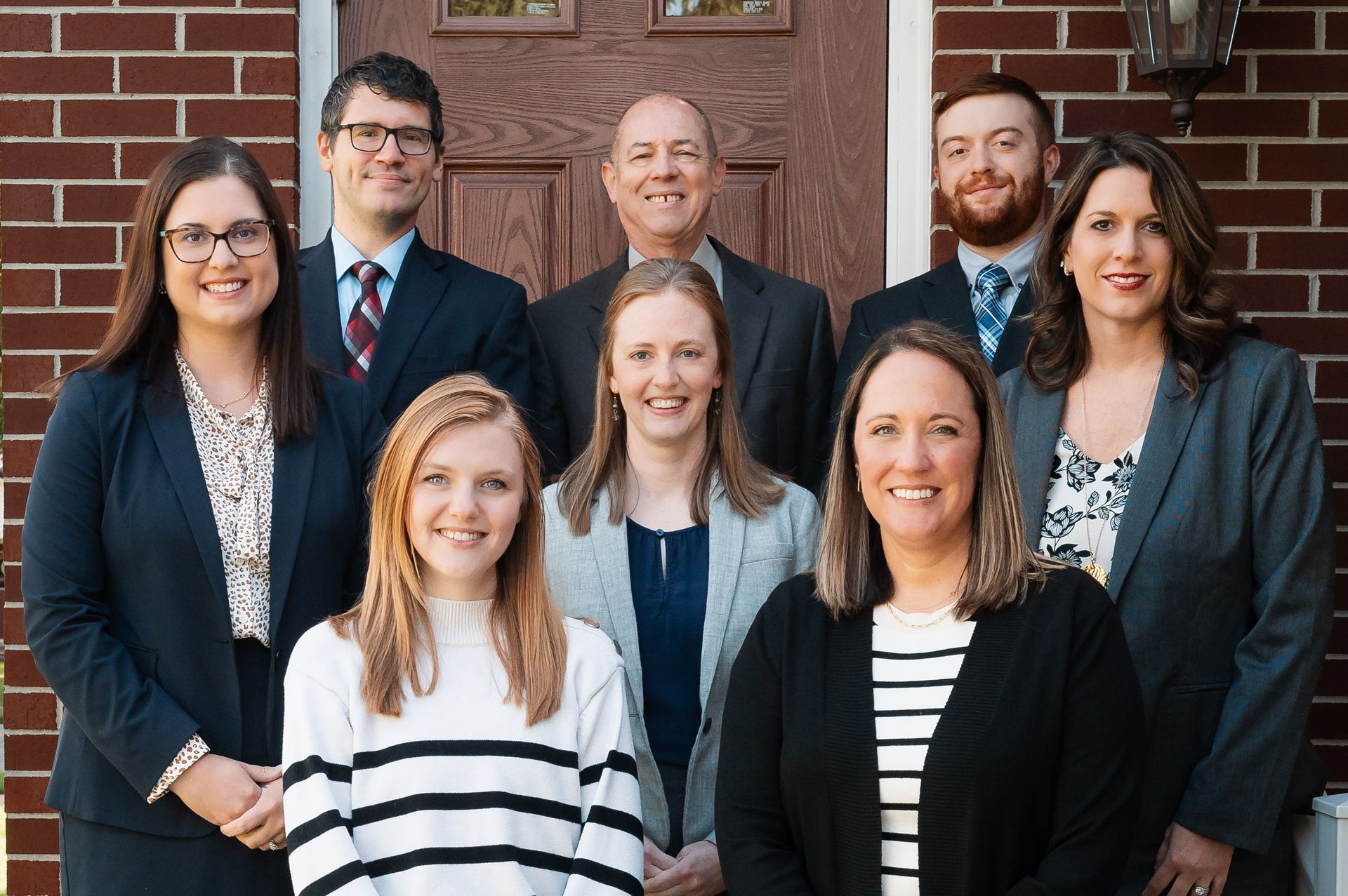 The staff of Turner Insurance stand outside the front doors of the office.