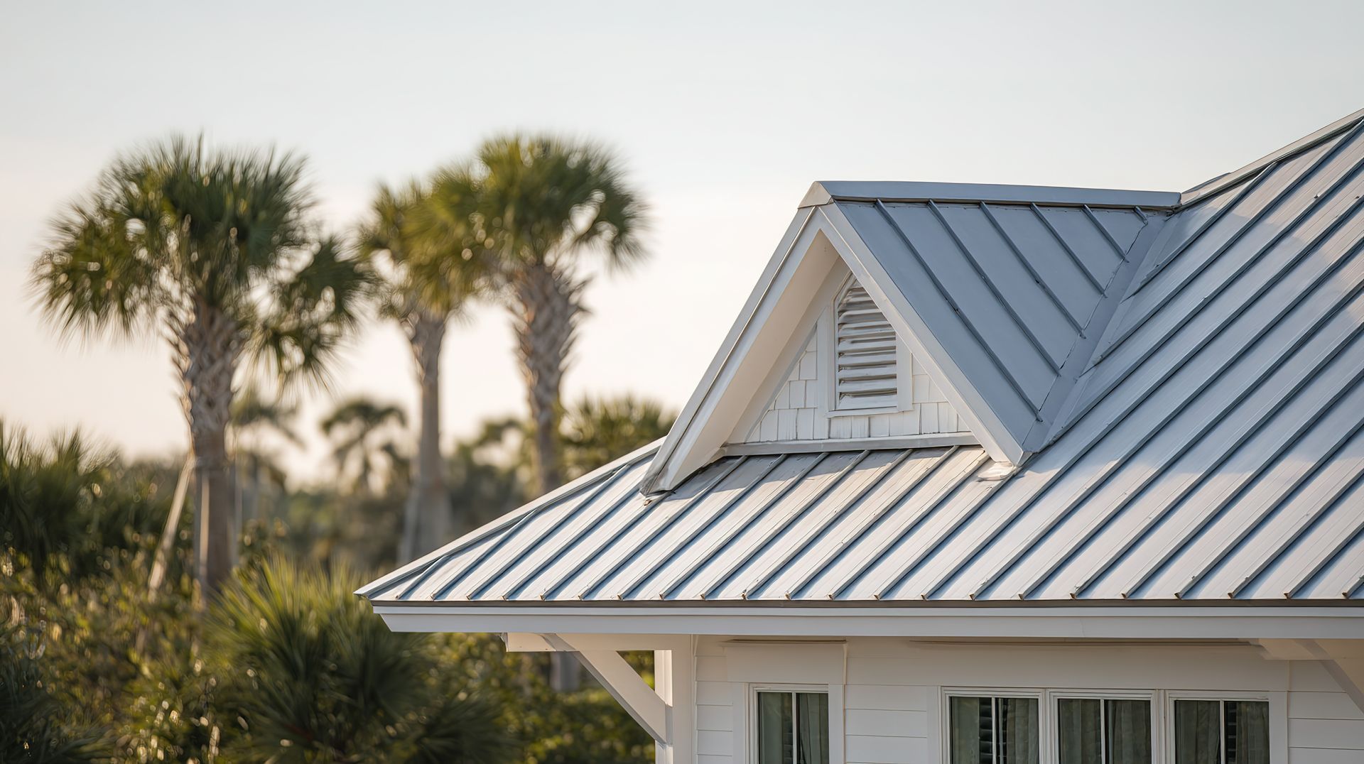 Beige stucco home with a clay tile roof, two-car garage, and paved driveway, under a blue sky.