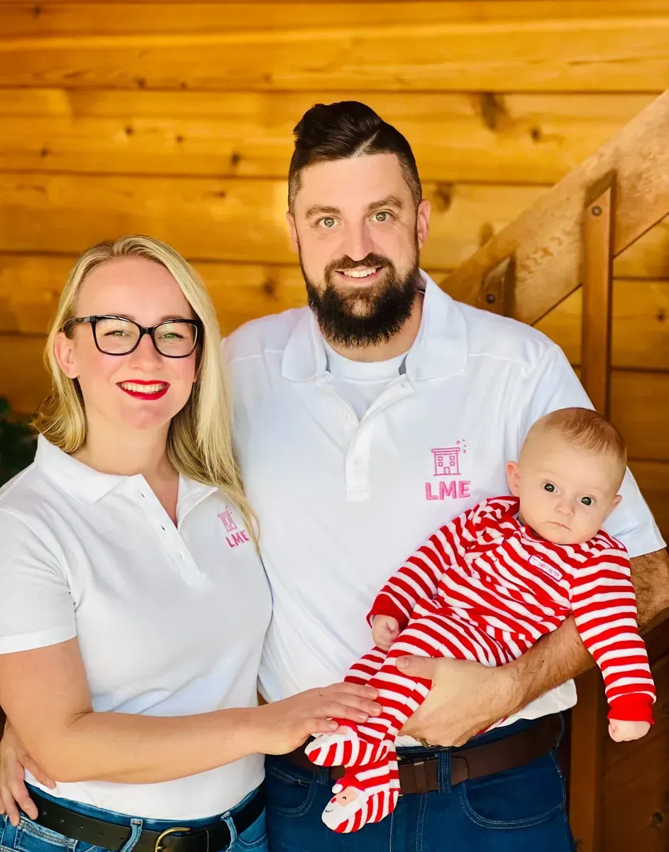 A man and a woman are holding a baby in their arms.
