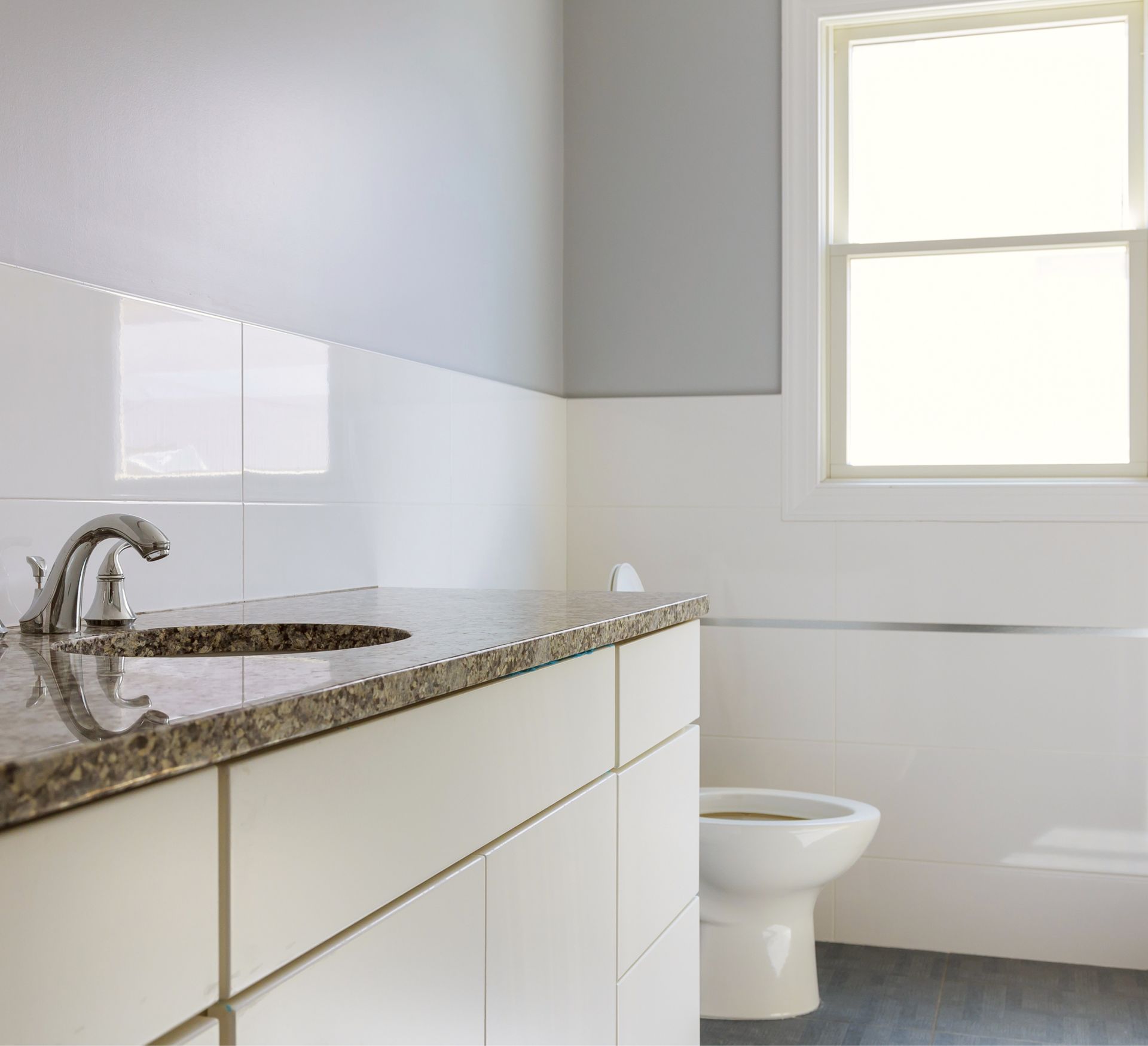 A bathroom with a sink and toilet and a window